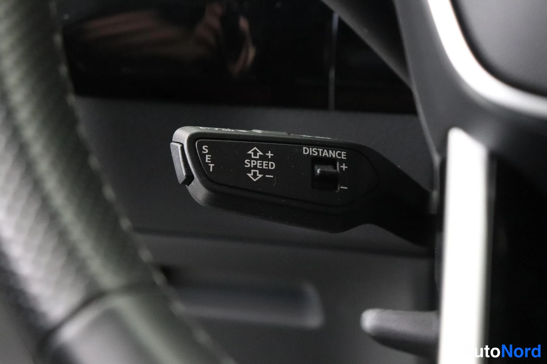 Sivulta: Ohjauspyörän vivun pää, jossa tekstit SET, SPEED +/− ja DISTANCE +/−.