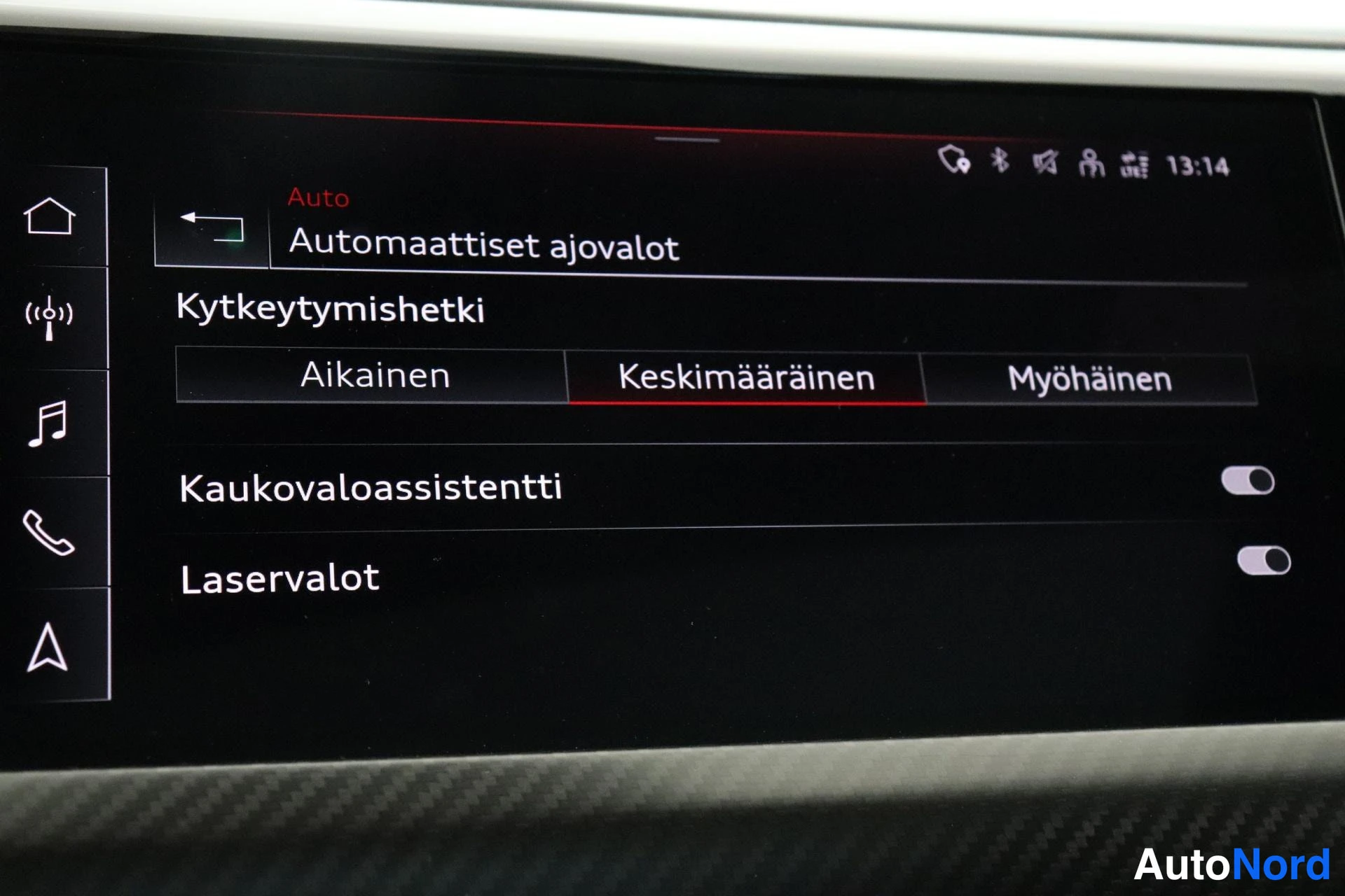 Edestä: Näytön valikko 'Automaattiset ajovalot': kytkeytymishetki 'Keskimääräinen', kaukovaloassistentti ja laservalot päällä.