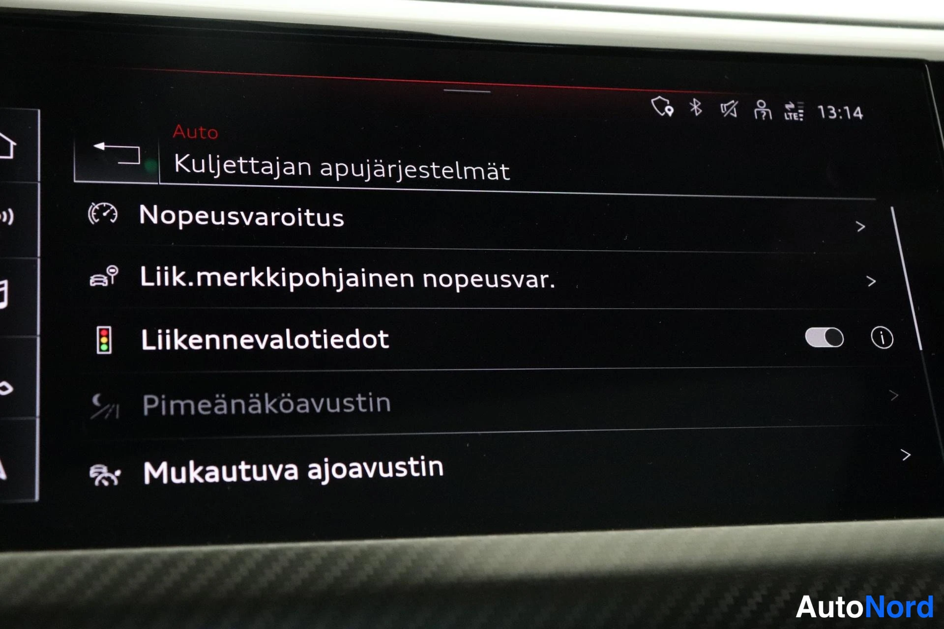 Edestä: Näytön valikko 'Kuljettajan apujärjestelmät': nopeusvaroitus, liikennemerkkipohjainen nopeusvaroitus, liikennevalotiedot, pimeänäköavustin ja mukautuva ajoavust