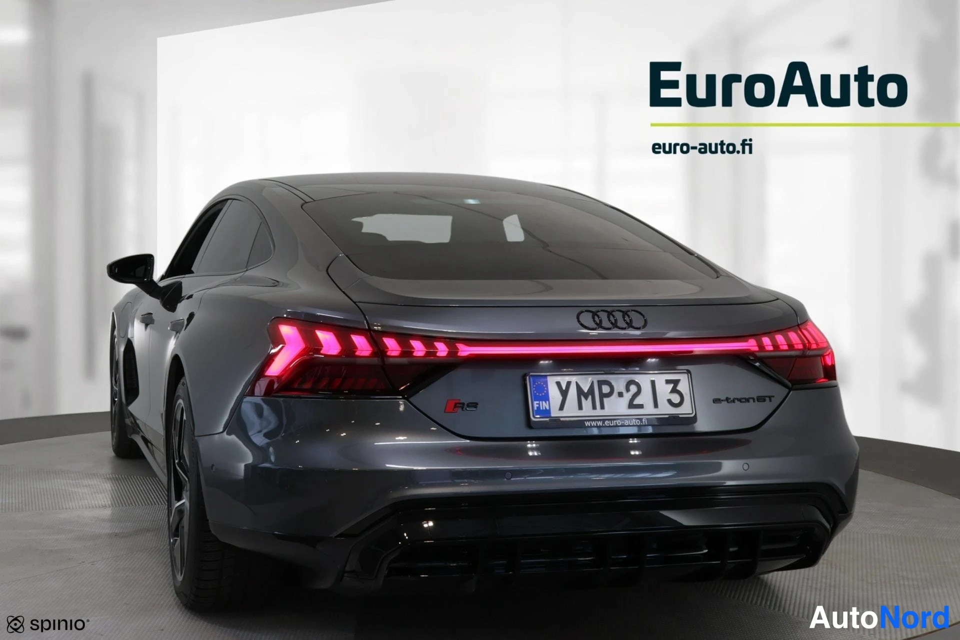 Takaviisto: Takakulma: harmaa Audi e-tron GT quattro. Punainen LED-taivaltahtien erottuu takavalossa. Etupää ja kylki eivät näy.