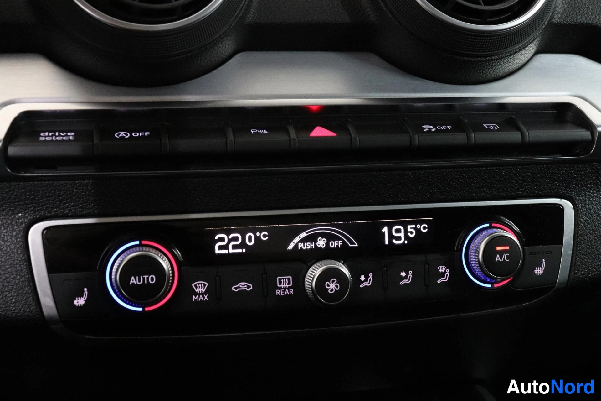 Muu: Auton ilmastointilaitteen hallintapaneeli lämpötilanäytöillä 22,0 °C ja 19,5 °C sekä AUTO-, A/C-, MAX- ja REAR-napeilla.