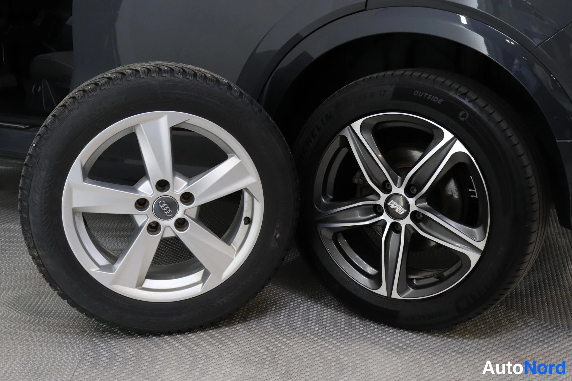 Sivulta: Kaksi Audi-alumiinivannetta sivuttain, vasemmassa hopea Audi-vanne, oikeassa tumma RS-vanne Michelin-rengas.