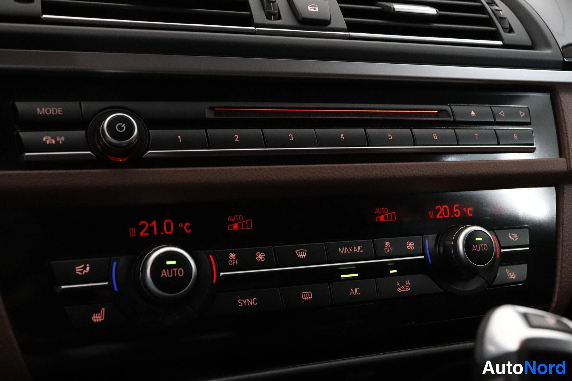 Yksityiskohta: Dashboard center console showing dual-zone climate control system with digital displays reading 21.0 °C and 20.5 °C, heating controls for driver and front passe