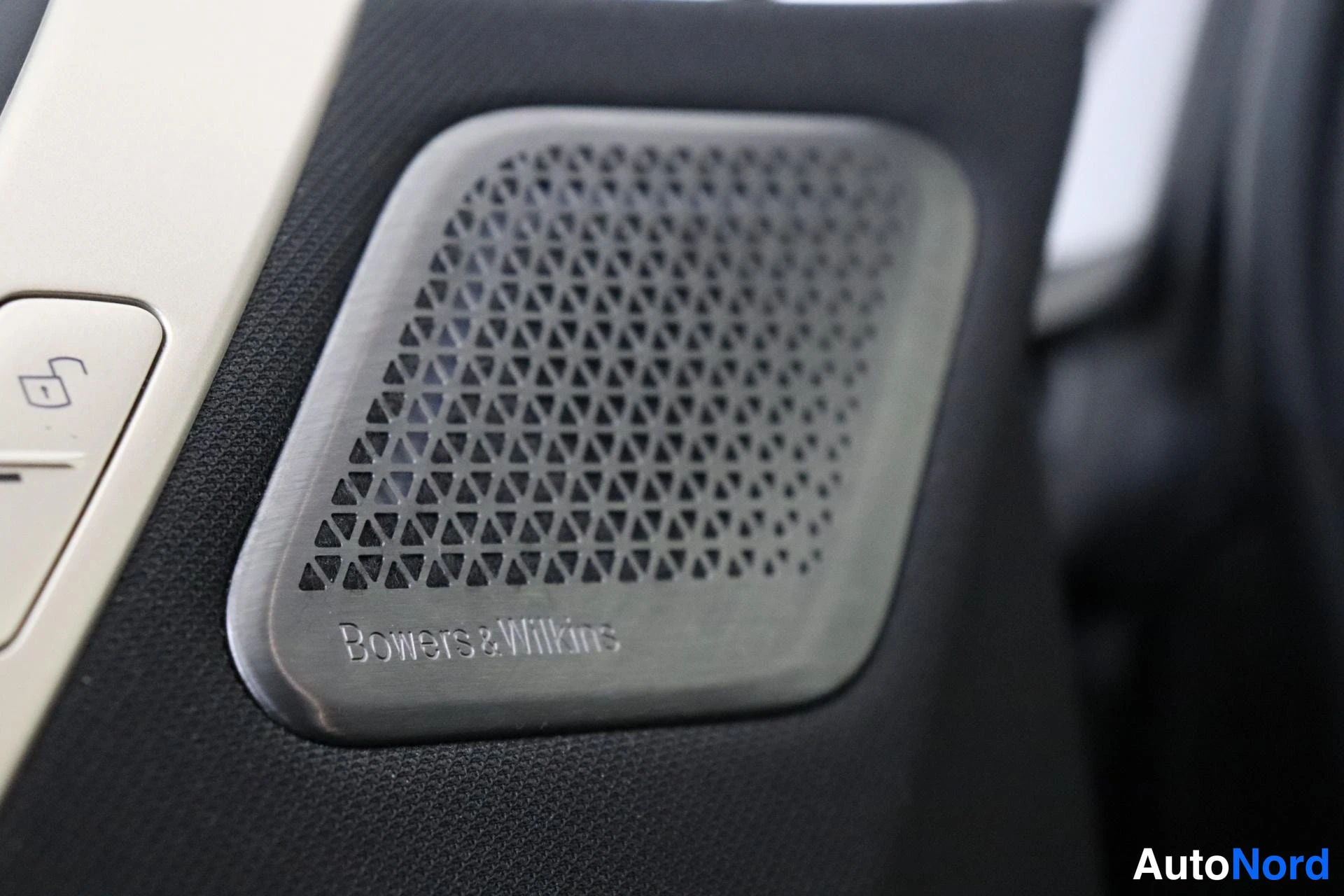 Yksityiskohta: Lähikuva Bowers & Wilkins -äänijärjestelmän kaiutinkotelosta ovipaneelissa.