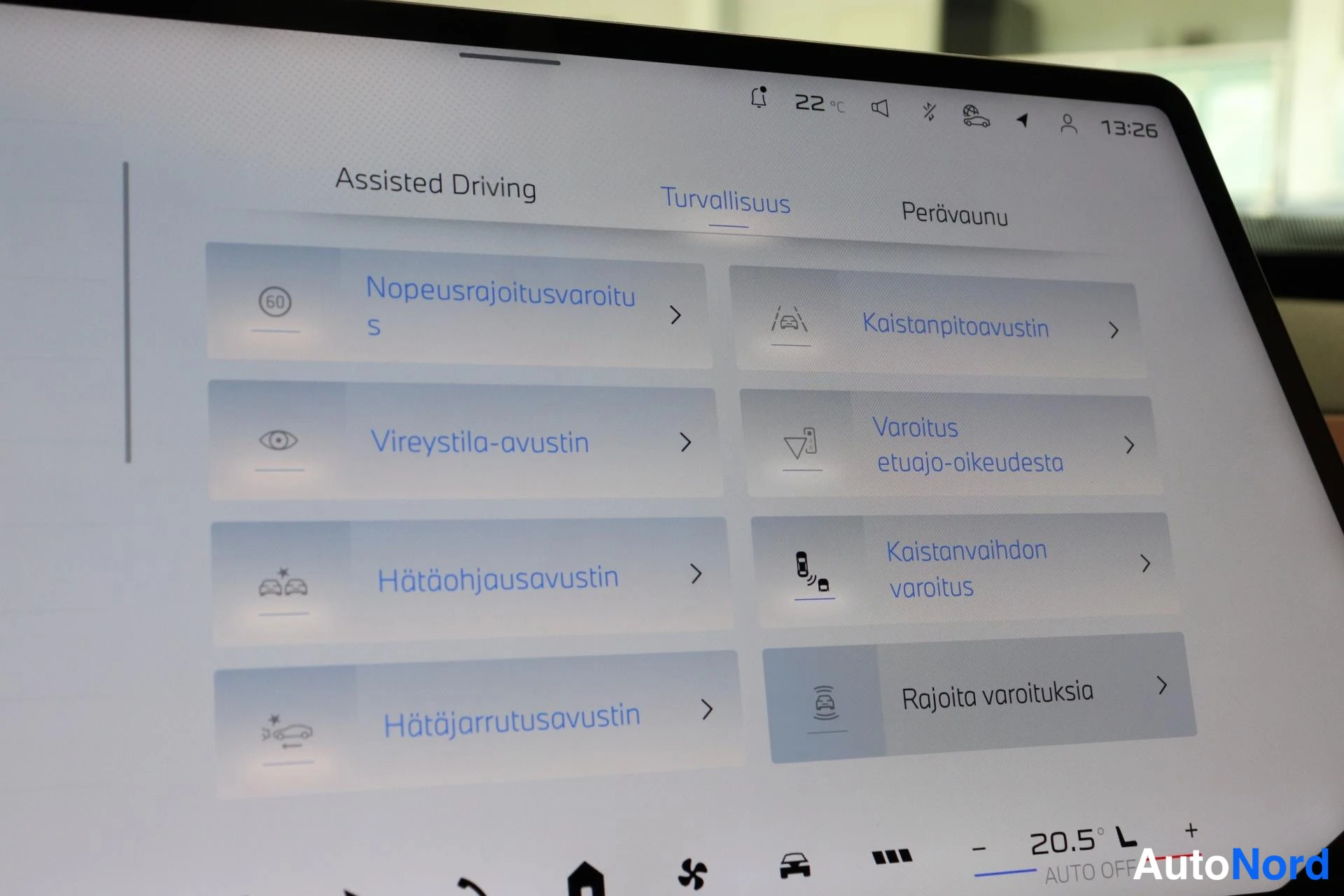 Ohjaamo: Uudelleenohjautuva näytön kuvaajataulu. Näytöllä lukee 'Hätäohjausavustin' (Emergency Steering Assistant) ja 'Kaistanvaihdon varoitus'. Tämä kuvaa auton ohjaamo
