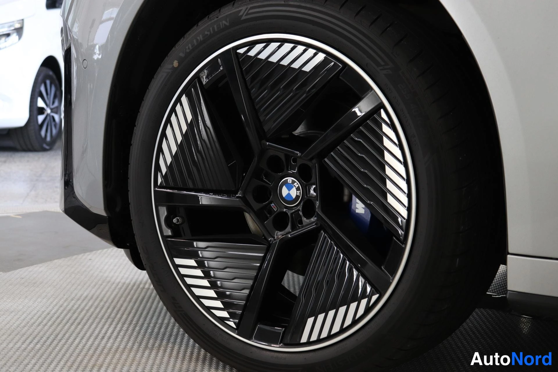 Sivulta: Musta BMW-tuotantovanne ja polkijyväinen rengas autosta, joka on vaalean hopeanvärinen