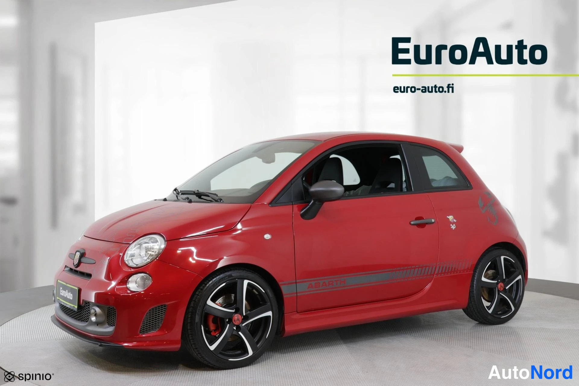 Sivulta: Red Fiat Abarth 595 shown in profile from the driver's side. The view captures the full left flank, front bumper section, and open driver's window showing parti
