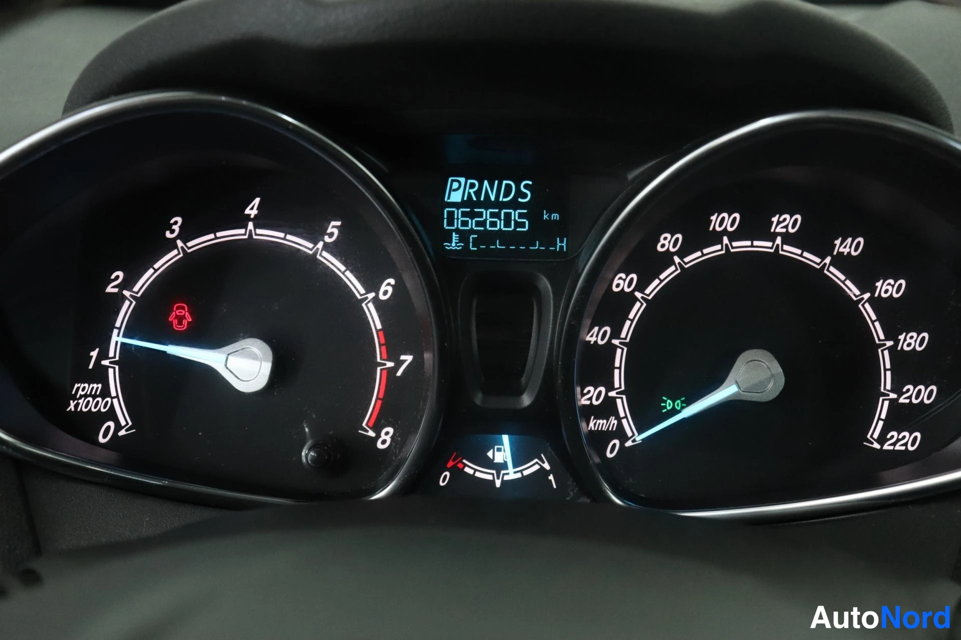 Edestä: Mittaristo lähikuvassa: kierrosmittari (0–8 x1000 r/min) ja nopeusmittari (0–220 km/h); keskinäytössä vaihdelaatikon kirjaimet P R N D S ja matkamittarin lukema