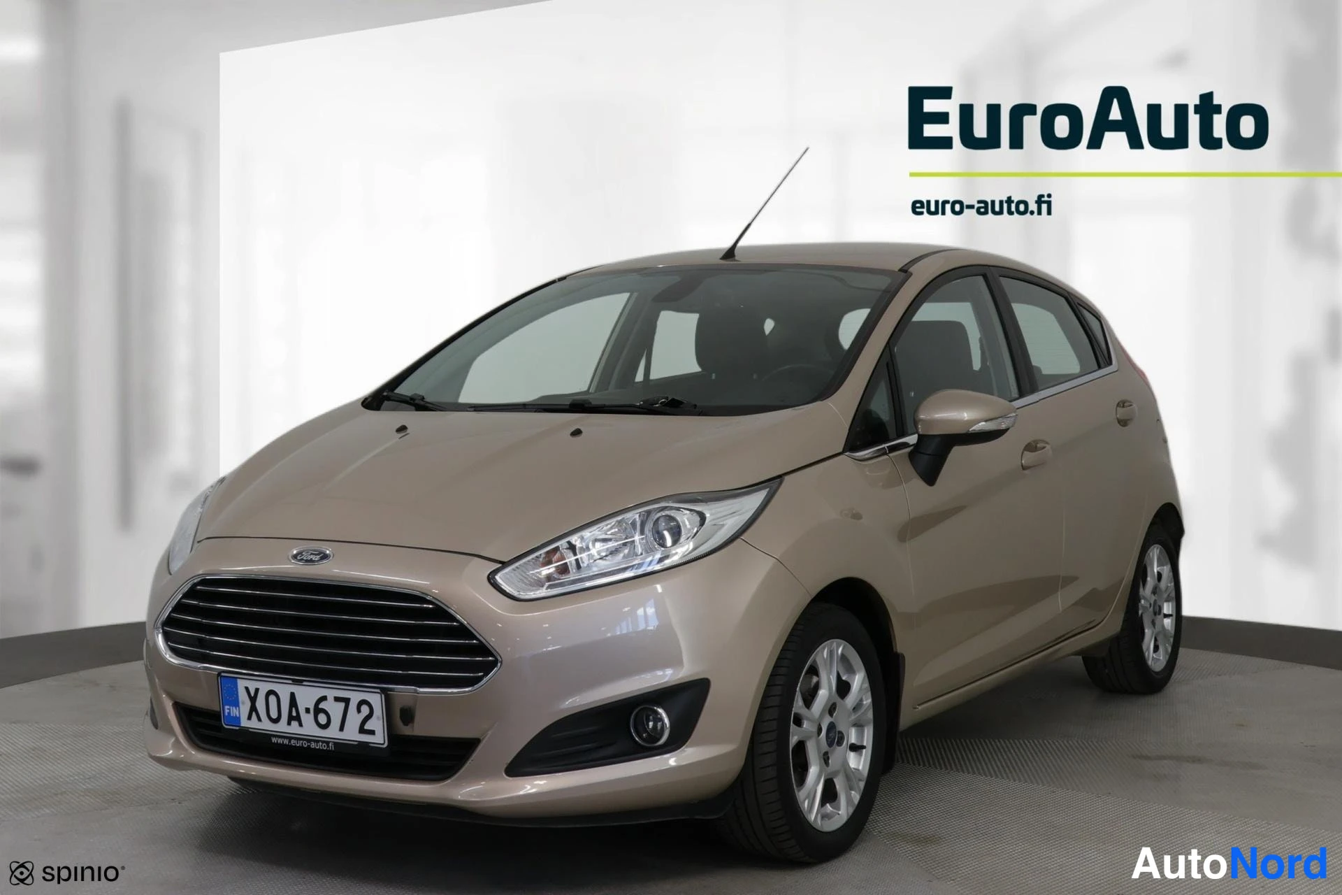 Edestä: Kultaharmaa Ford Fiesta -etunäkymä ilman takaa. Keraamiset valot ja alumiinirengas.