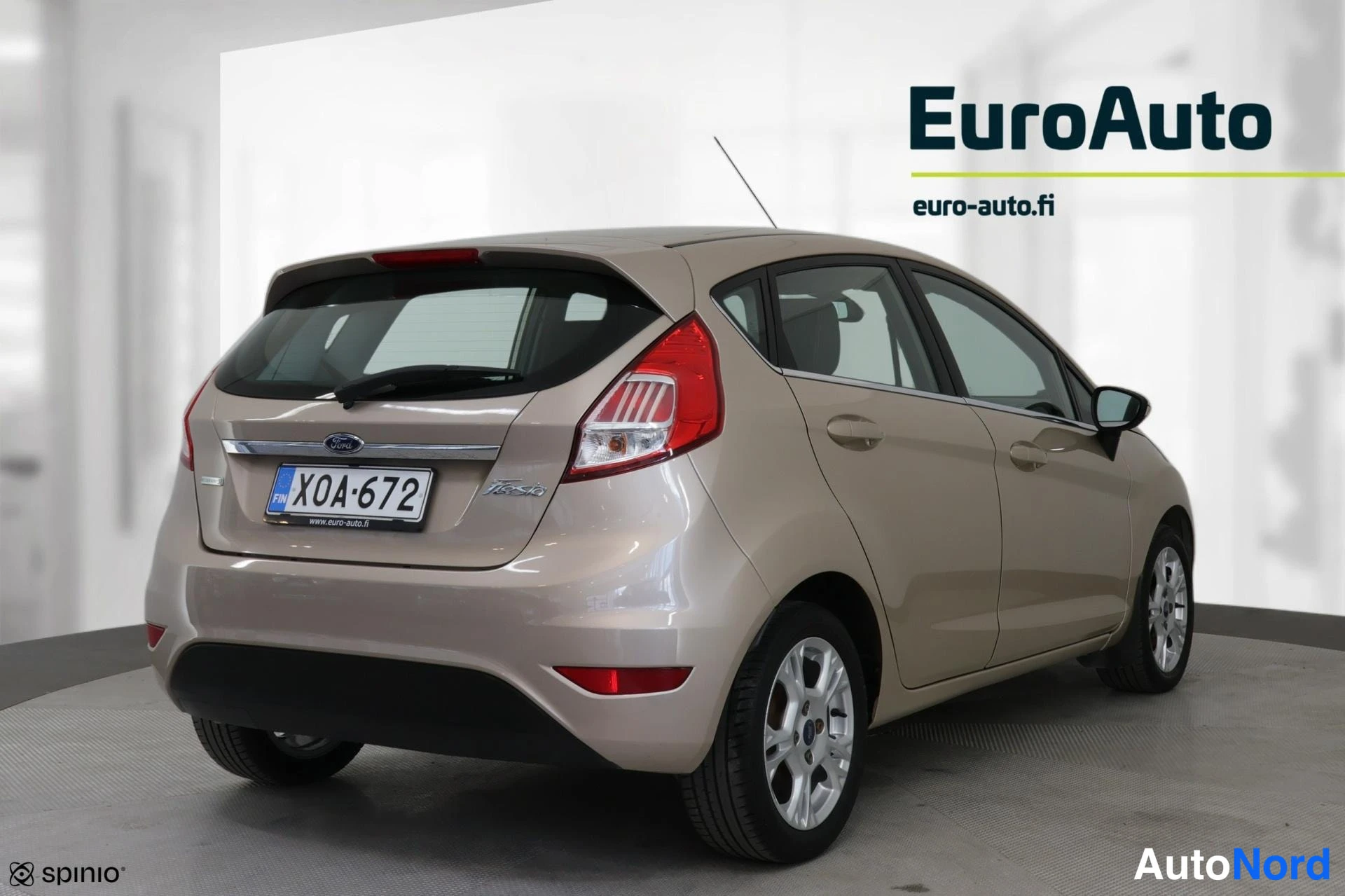 Sivulta: Right side of a beige Ford Fiesta hatchback showing four doors and alloy wheels.