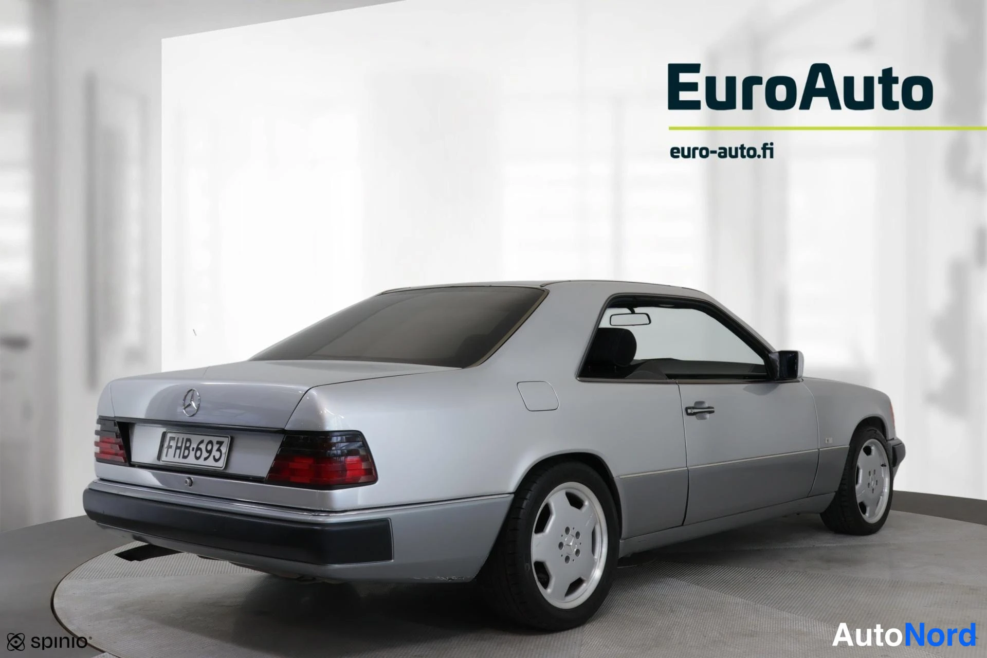 Takaviisto: Hopeanvärinen Mercedes-Benz 300 CE -coupé kuvattuna takaa vasemmalta sivulta, rekisterikilpi.