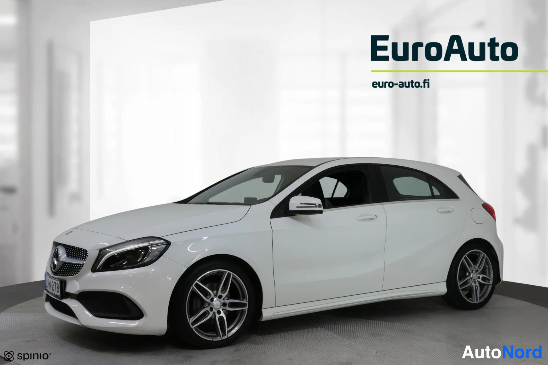 Etuviisto, nokka vasemmalle: Valkoinen Mercedes-Benz A -henkilöauto kolmella neljäsosaa etusta, keula vasemmalla.