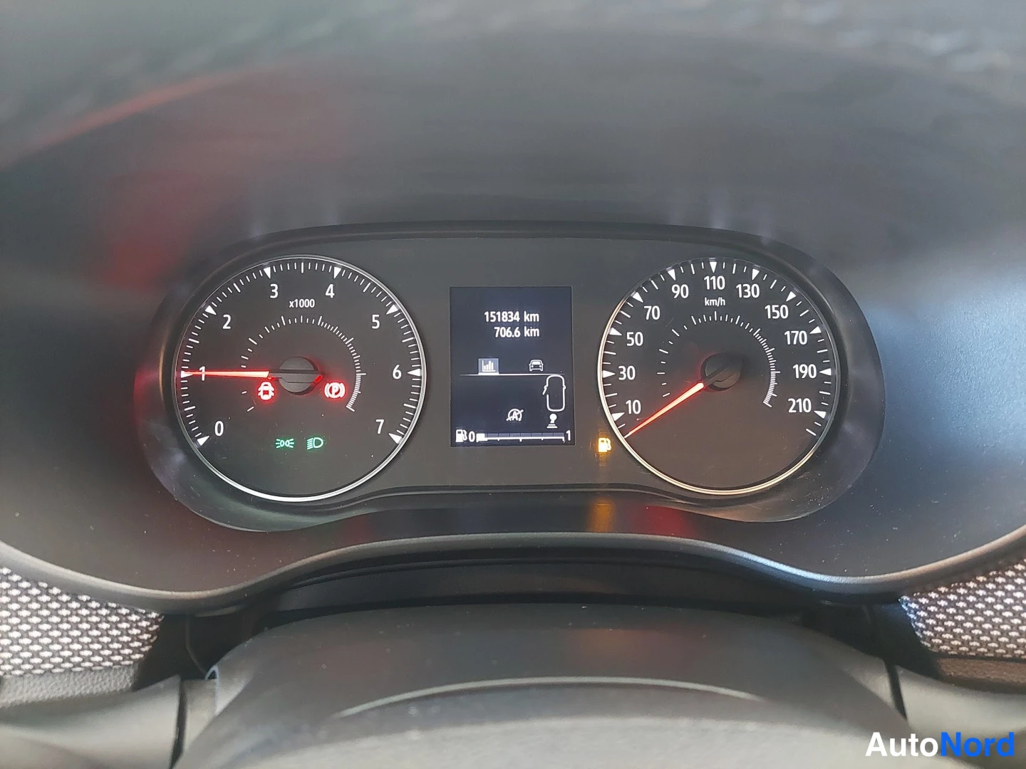Muu: Mittaristo lähikuvassa: kierrosmittari vasemmalla, nopeusmittari oikealla ja keskinäytöllä lukemat 151834 km ja 706,6 km.