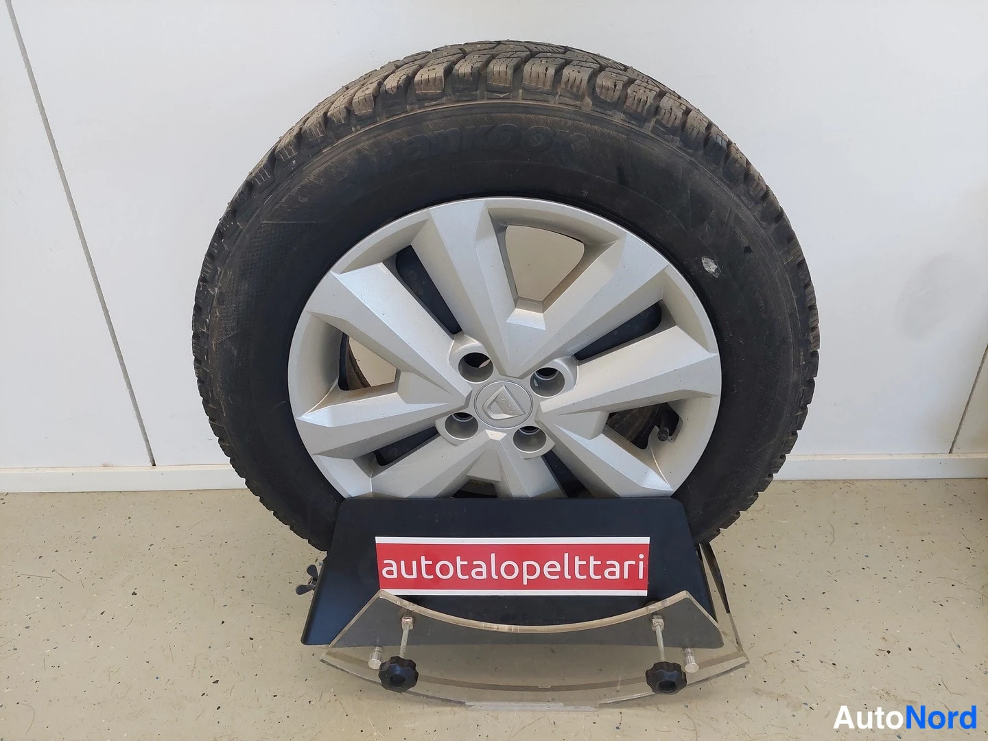 Muu: Nastarenkias vanteella mustalla jalustalla, jonka kyljessä lukee autotalopeltari