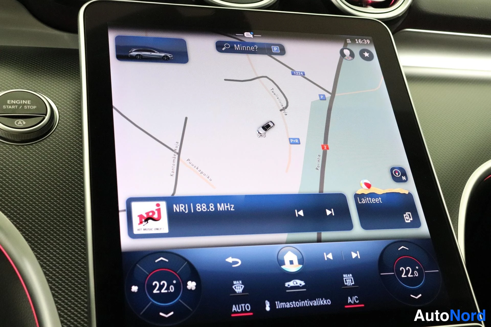 Yksityiskohta: Lähikuva infotainment-näytöstä: navigointikartta, NRJ 88.8 MHz -radio ja ilmastointiasetukset (22,0 °C). Vasemmalla ENGINE START / STOP -painike.