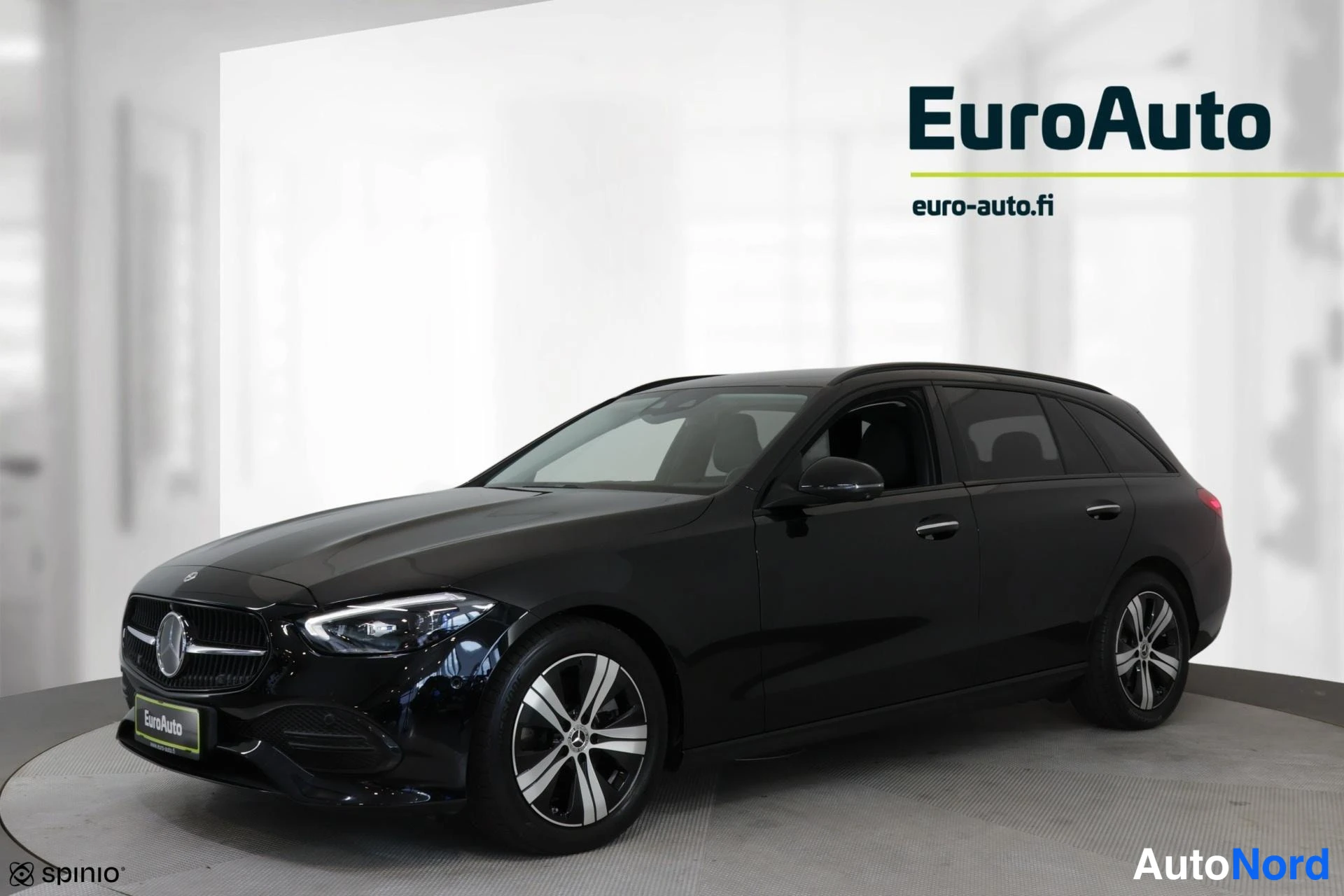 Etuviisto, nokka vasemmalle: Musta Mercedes-Benz-farmari kuvattuna etukulmasta, keula vasemmalla, valkoisessa studiossa.