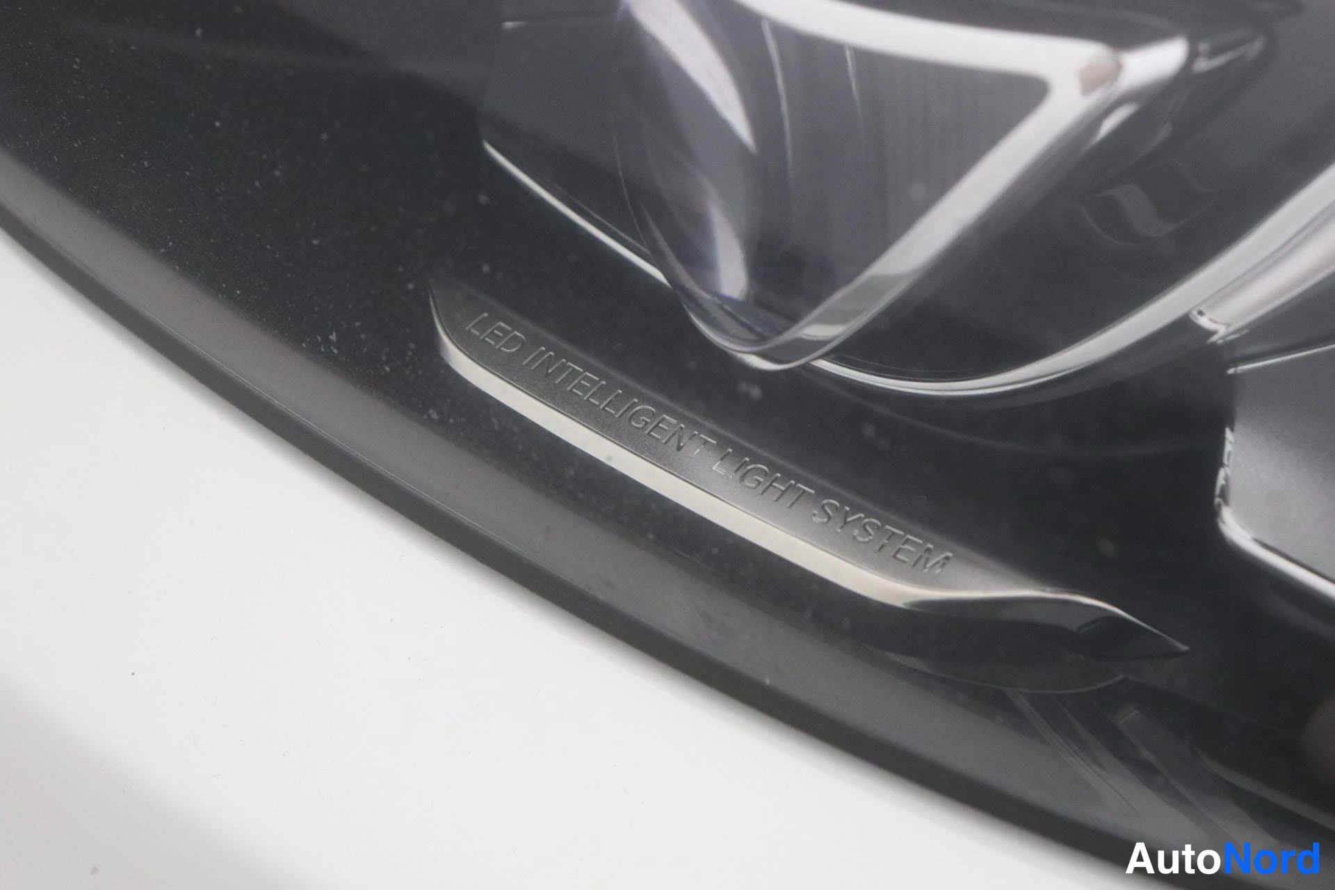 Yksityiskohta: Lähikuva auton edestä osoittavasta LED-tekstillä: LED INTELLIGENT LIGHT SYSTEM.