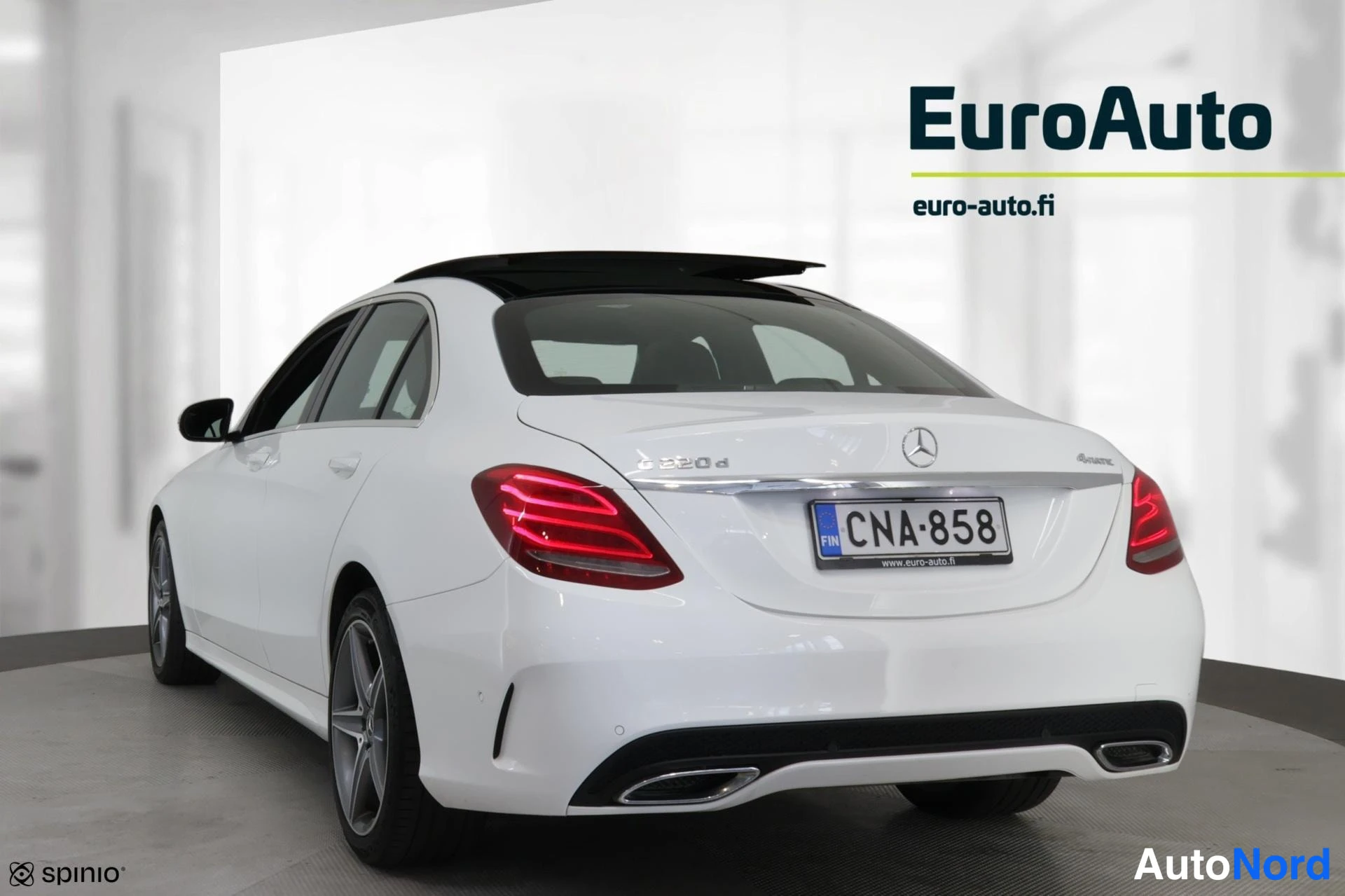 Takaviisto: Mercedes-Benz C-sedanin takakulma näkyy vasemmalta, valkoinen koripaneli, -kilpi, panoraamakatto avattuna.