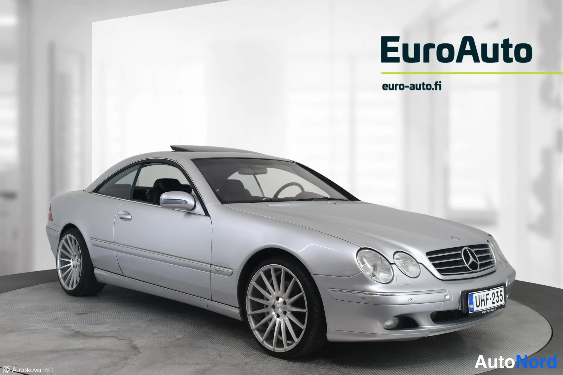 Etuviisto, nokka oikealle: Hopeinen Mercedes-Benz CL -coupé etukulmakuvassa keula oikealla, rekisterikilpi, vaalea studiotausta.