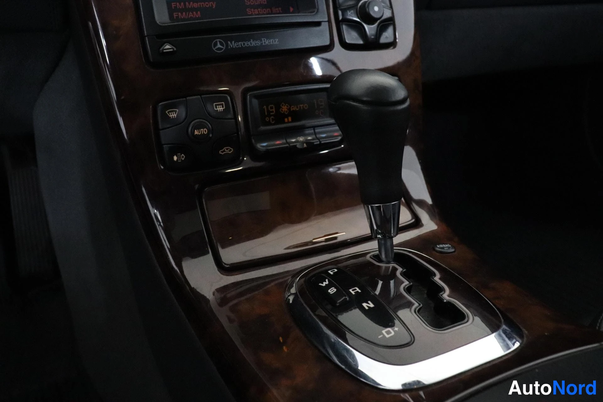 Ohjaamo: Gear selector with automatic transmission range indicators (P, R, N, D/S) next to climate control display reading 19 degrees Celsius.
