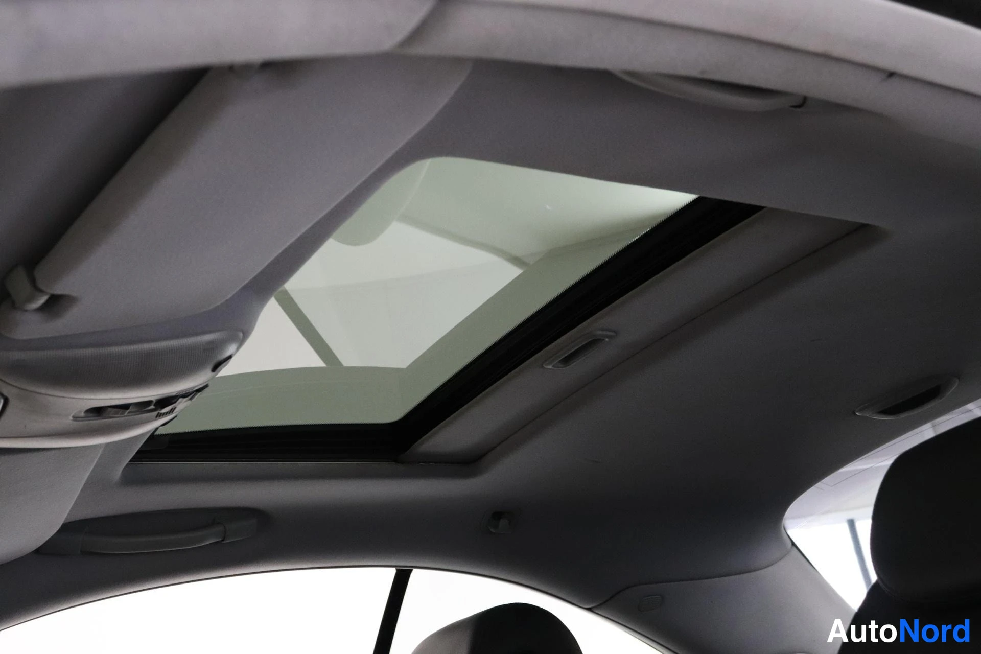 Ohjaamo: Interior view looking up at a panoramic glass roof set into the headliner.