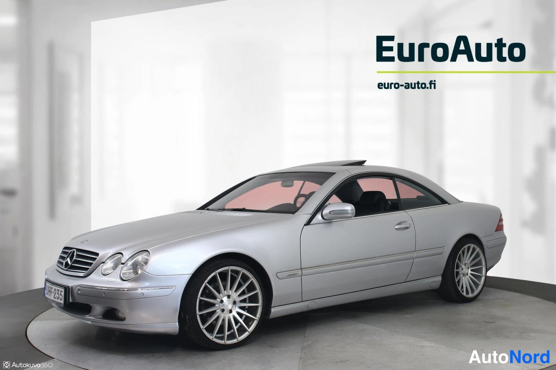 Etuviisto, nokka vasemmalle: Hopeinen Mercedes-Benz CL -coupé pitkässä etukulmakuvassa keula vasemmalla, koko kylki ja takaosa näkyvissä.