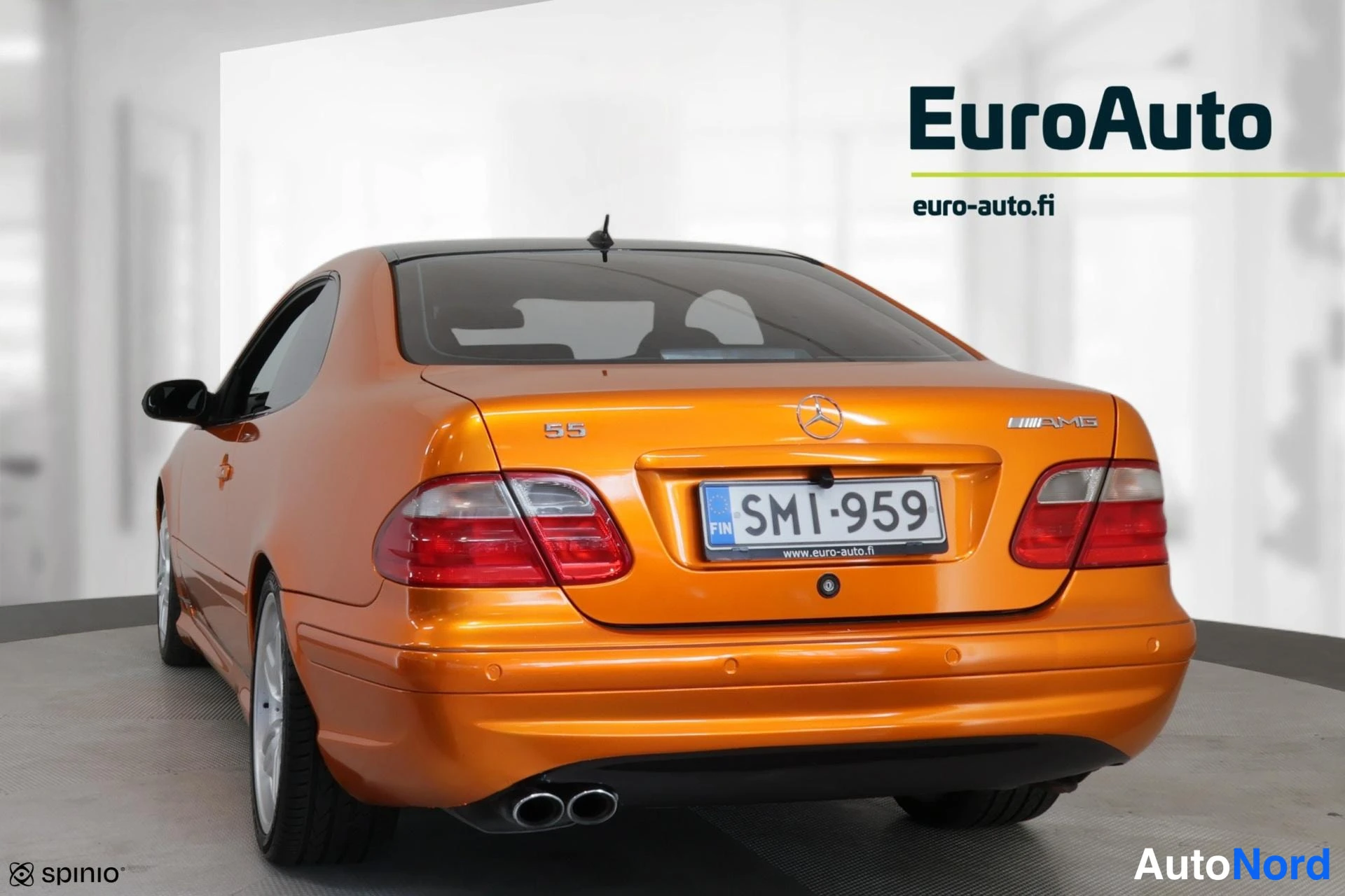 Takaviisto: Orange Mercedes coupe rear three-quarter from the right side with visible tail lights and plate