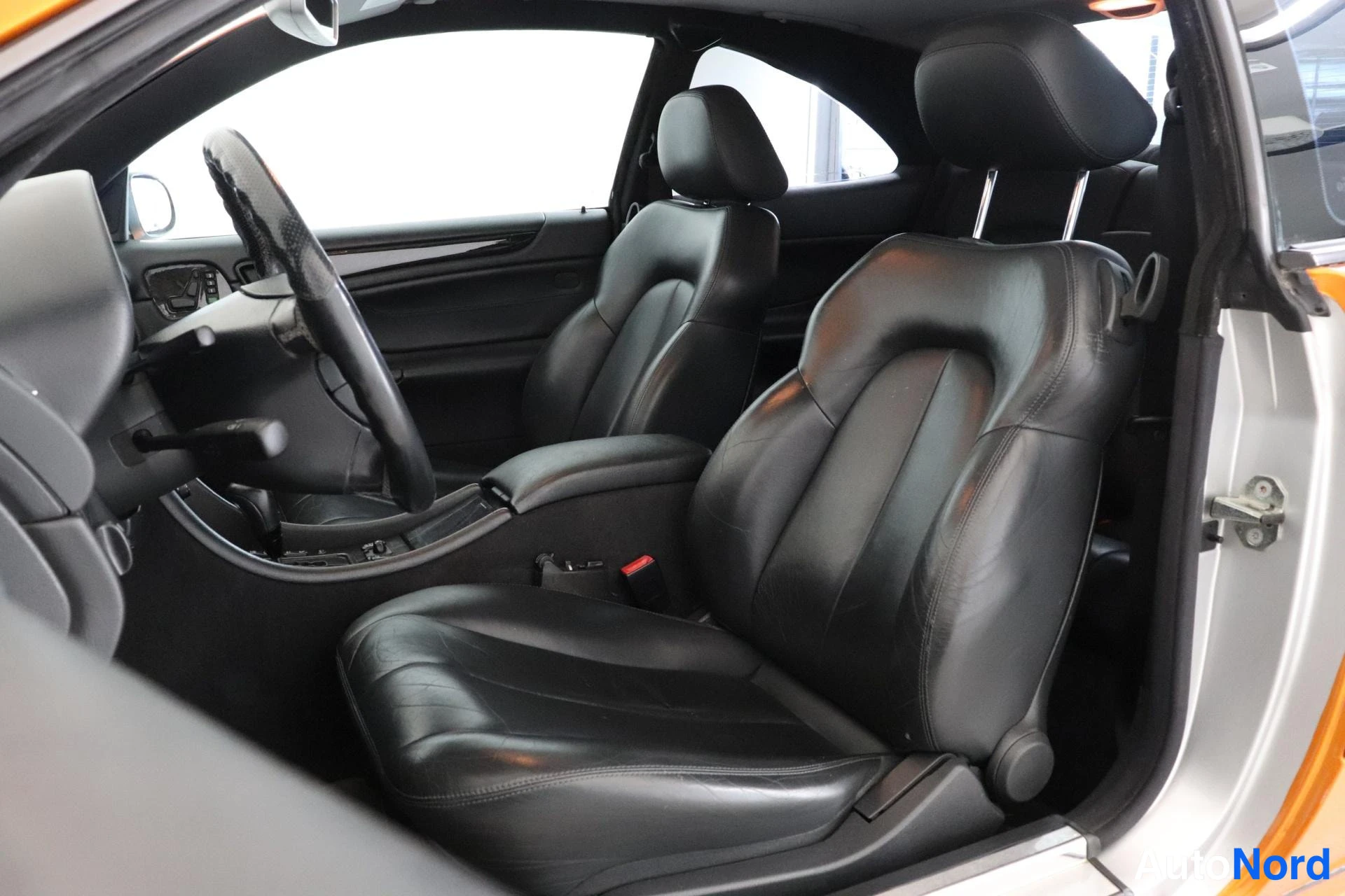 Etuistuimet: Front interior shot focusing on two black leather bucket seats within the cabin