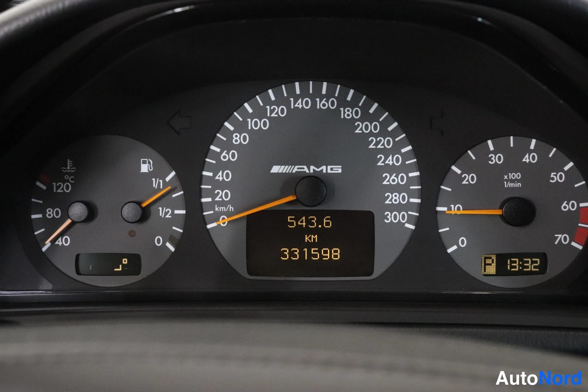 Yksityiskohta: Mittaristo, jonka nopeusmittarissa on AMG-logo ja asteikko 0–300 km/h. Digitaalinäytössä lukee 543,6 km ja kokonaisajomäärä 331598 km. Kello näyttää 13:32 ja po