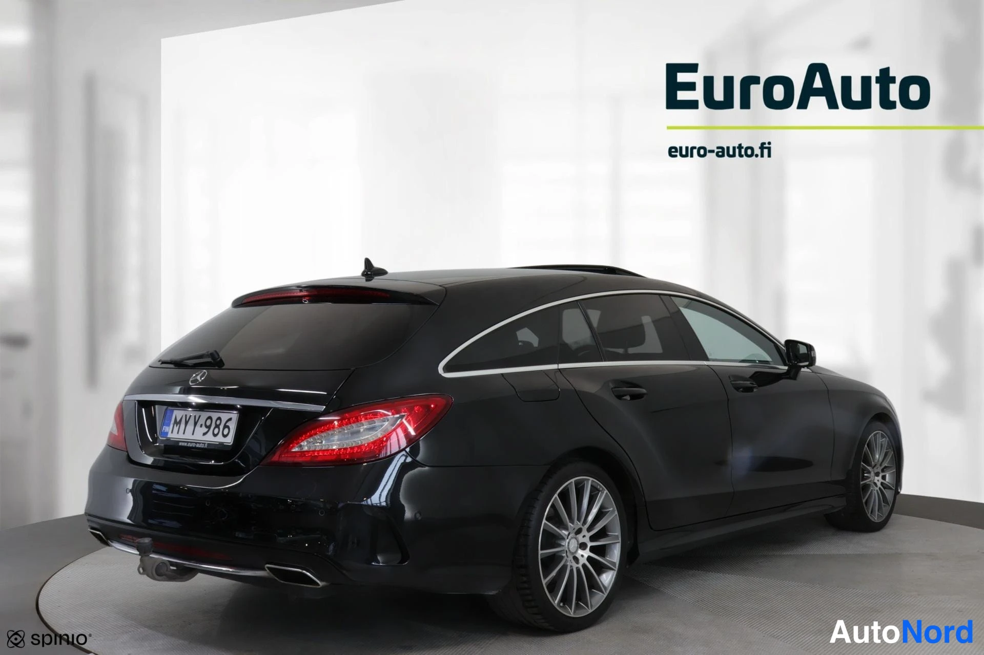Takaviisto: Vasemman puolen kolminkertainen kuvio mustasta Mercedes-Benz-hatchbackista. Rekkari numero on selvästi luettavissa. Alustat ovat alumiinivanteilla varustetut.