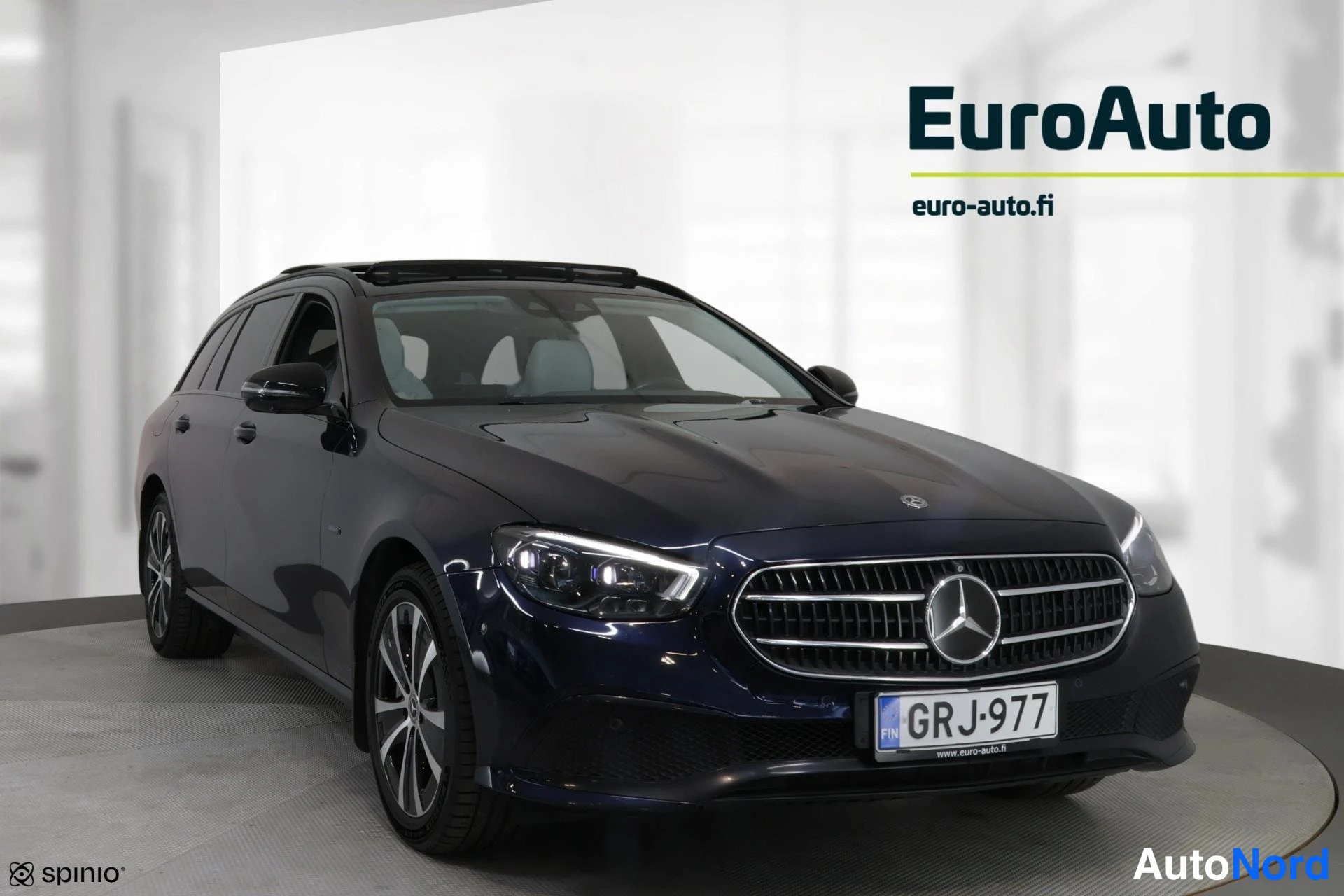 Etuviisto, nokka oikealle: Tummansininen Mercedes-Benz-farmari kuvattuna edestä oikealta kulmasta; etusäleikkö, Mercedes-tähti ja tumma lasikatto näkyvissä.