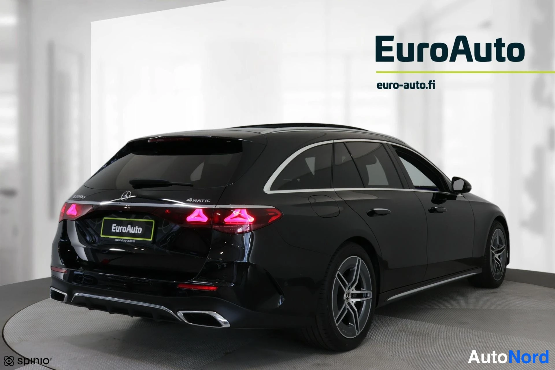 Takaviisto: Musta Mercedes-Benz 220 d -maastomallinen maantieauto näkyy taka-vikurikulmasta. Takavalot ja '4MATIC'-etiketti ovat erottuvissa, samoin EuroAuto-logon numeroke