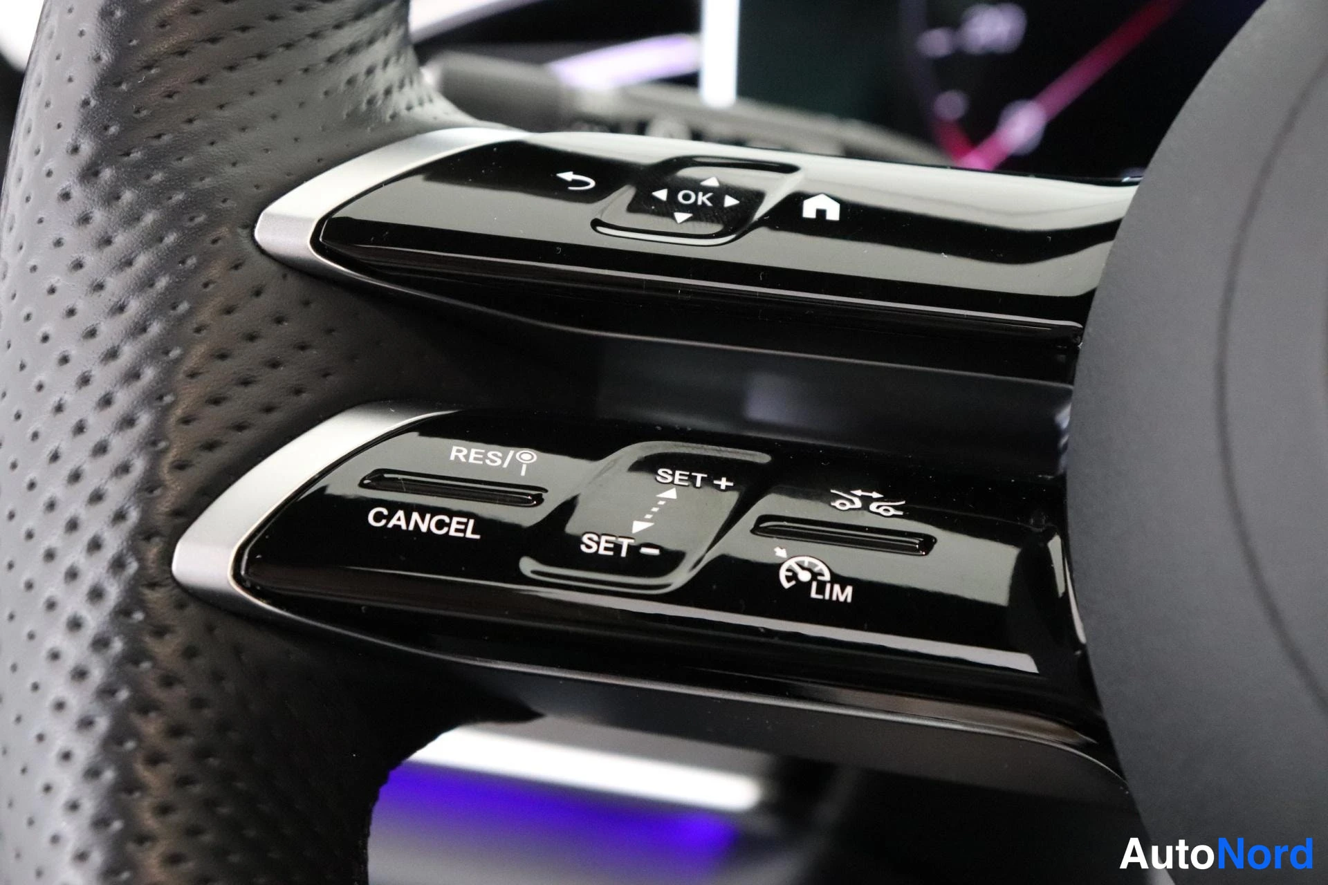 Yksityiskohta: Close-up of the right-hand multifunction steering wheel controls. Buttons for cruise control function are clearly visible, including 'RES/' (resume), 'CANCEL',