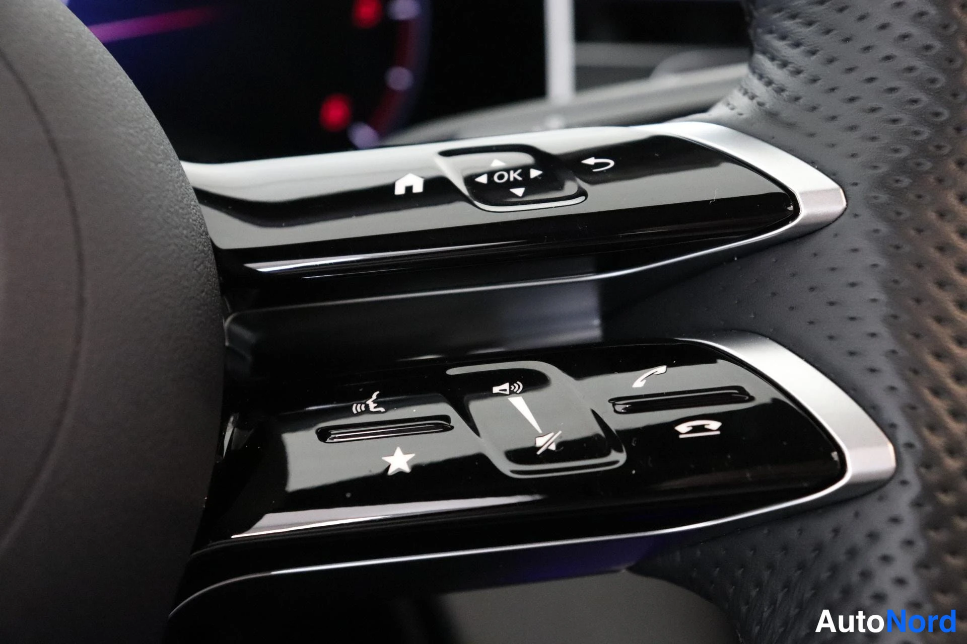 Yksityiskohta: Close-up of the left-hand multifunction steering wheel controls. The buttons for audio and phone functionality are visible, including call接听/ending buttons and