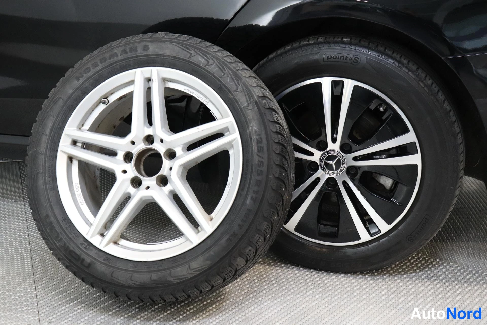 Yksityiskohta: Auton pyörät, joissa on Nokian Hakkapeliitti R5 talvarenkaat ja hopeanväriset kevytmetallivanteet sekä toinen renkaista Michelin renkaalla.