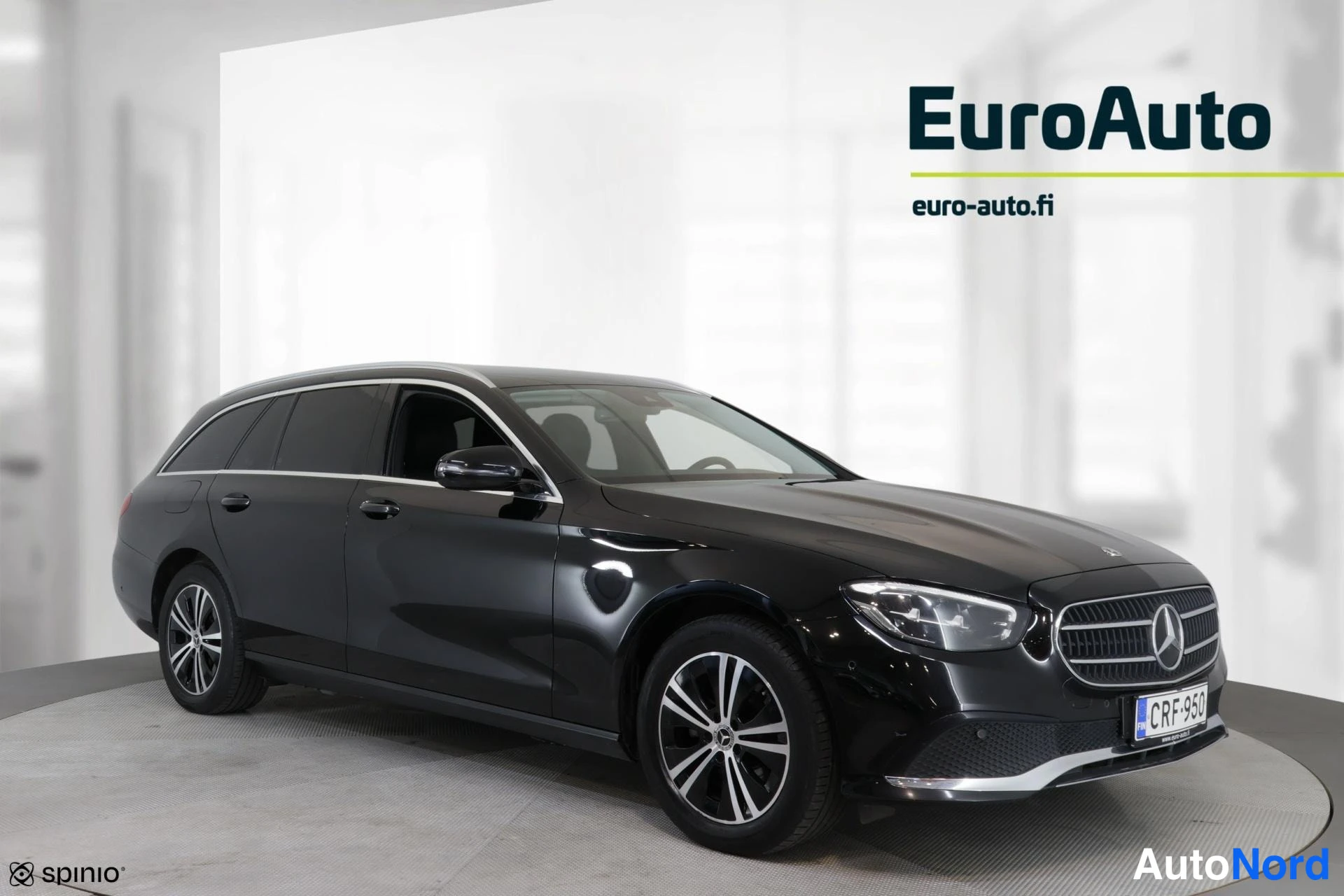 Sivulta: Musta Mercedes-Benz -farmariauto kuva puoliväriltä. Vasen sivu on selvästi näkyvissä, mutta etuosa ei ole kuvan pääosassa. Takalaatta ja EuroAuto logo näkyvät.