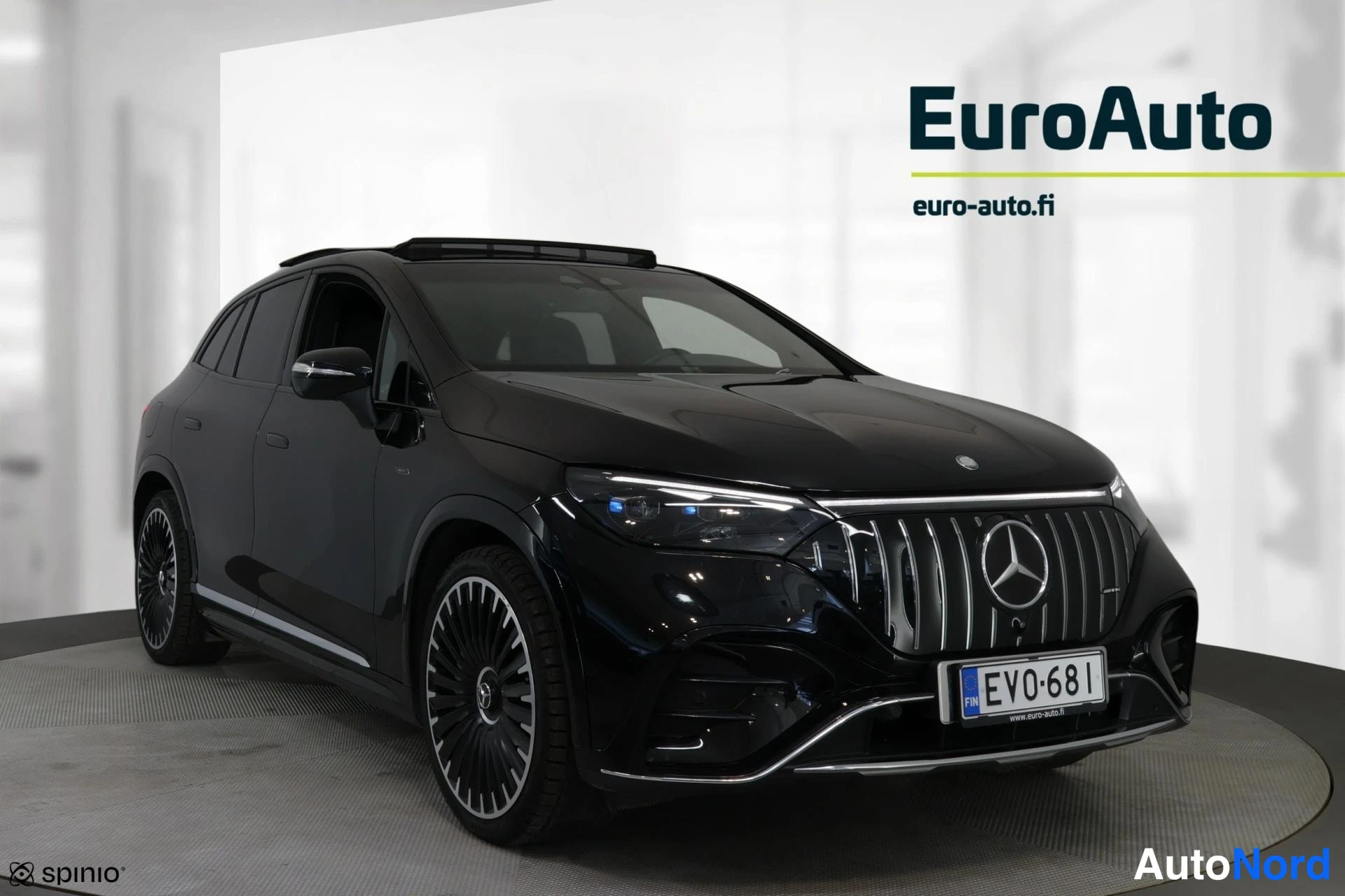 Etuviisto, nokka vasemmalle: Musta Mercedes-Benz EQE SUV nähtynä etuviistokulmasta vasemmalta. Autossa on kattohaat ja LED-eduvalot.
