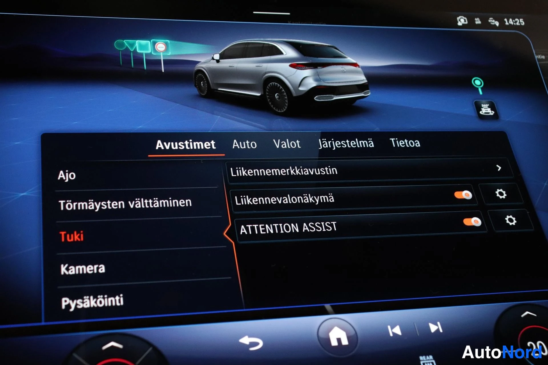 Sivulta: Infotainment-näytön Avustimet-valikko: vasemmalla valinnat Ajo, Törmäysten välttäminen, Tuki, Kamera ja Pysäköinti, oikealla Liikennemerkkiauttin sekä päällä ol