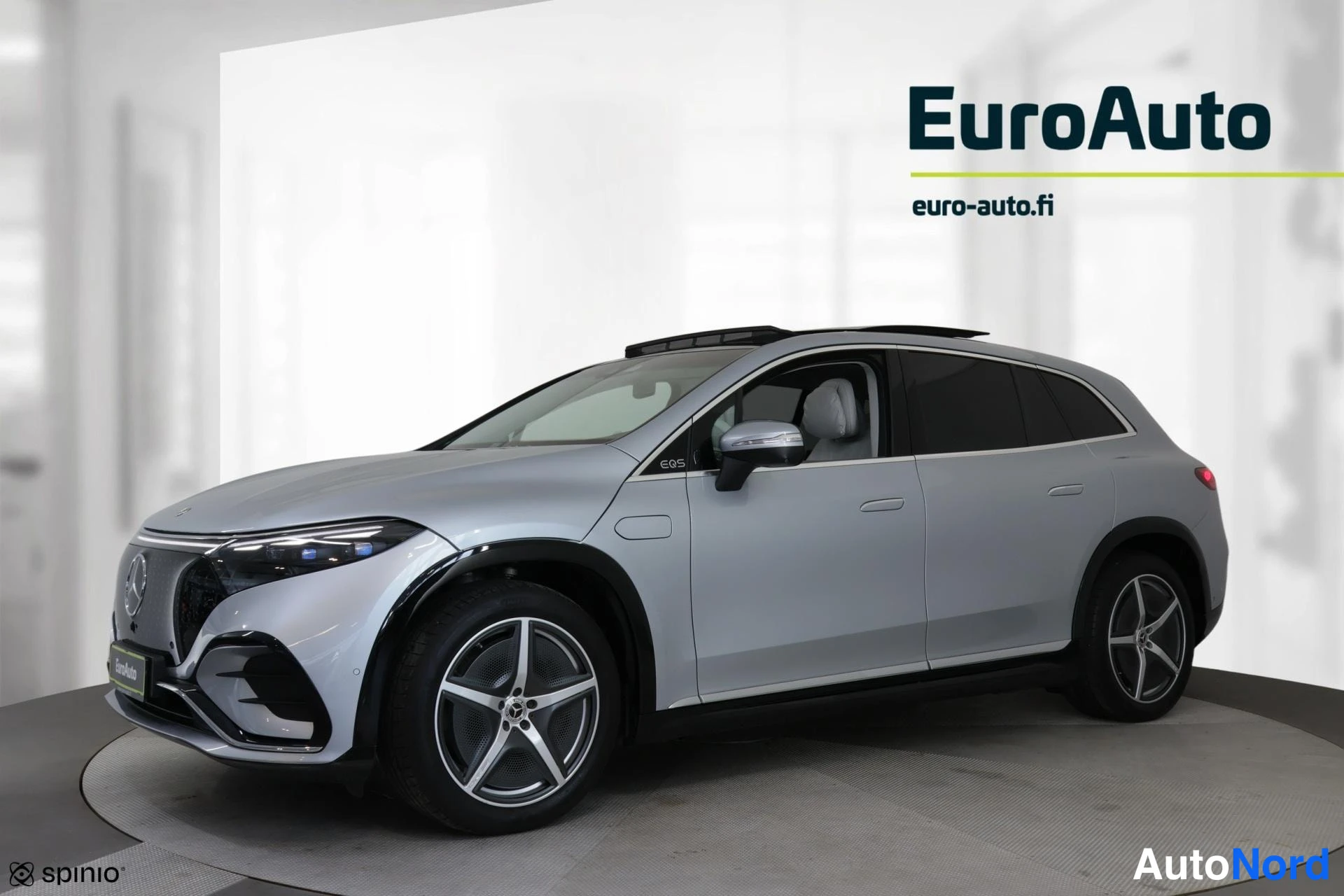 Etuviisto, nokka vasemmalle: Hopea Mercedes-Benz EQS edestä vasemmalta sivusuunnasta kuvattuna; panoraamalasikatto, kevytmetallivanteet ja EQS-tunnus etulokasuojassa näkyvät.