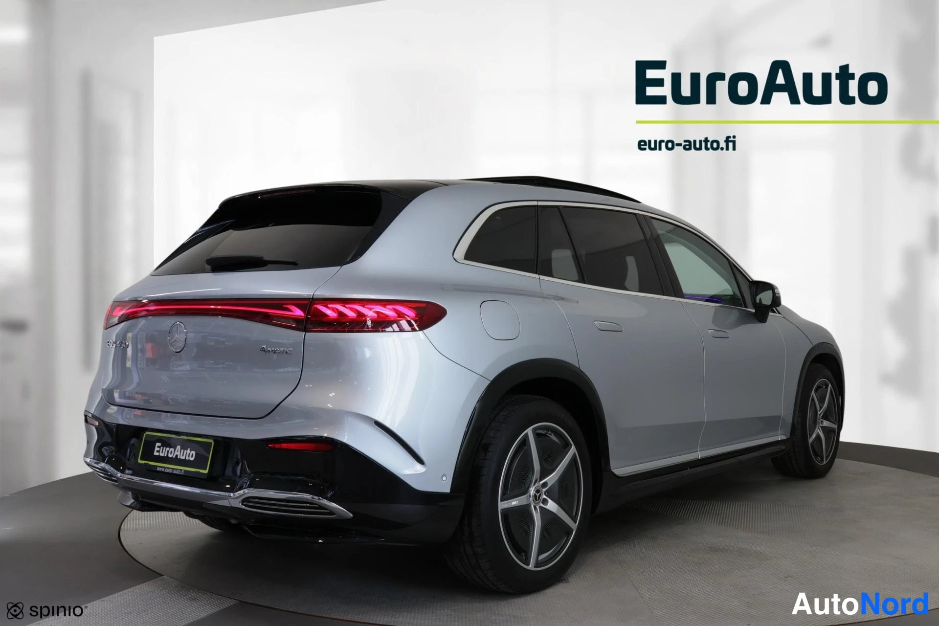 Takaviisto: Takaoikea kulma automallista hopeanharmaasta Mercedes-Benz EQS 450:stä. Auton takaosa ja oikea sivu näkyvät. Takavalot palavat kirkkaana viivanä.