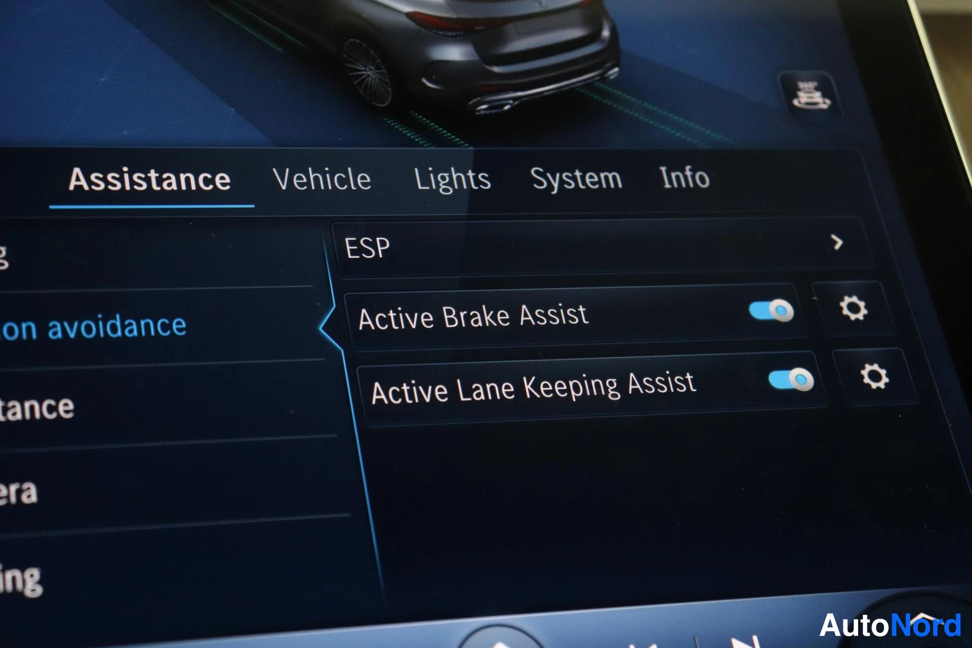Muu: Auton ohjausjärjestelmän digitalinen näyttö esittää 'Assistance' -valikon, jossa on aktivoinnit ESP, Active Brake Assist ja Active Lane Keeping Assist. Valikkos