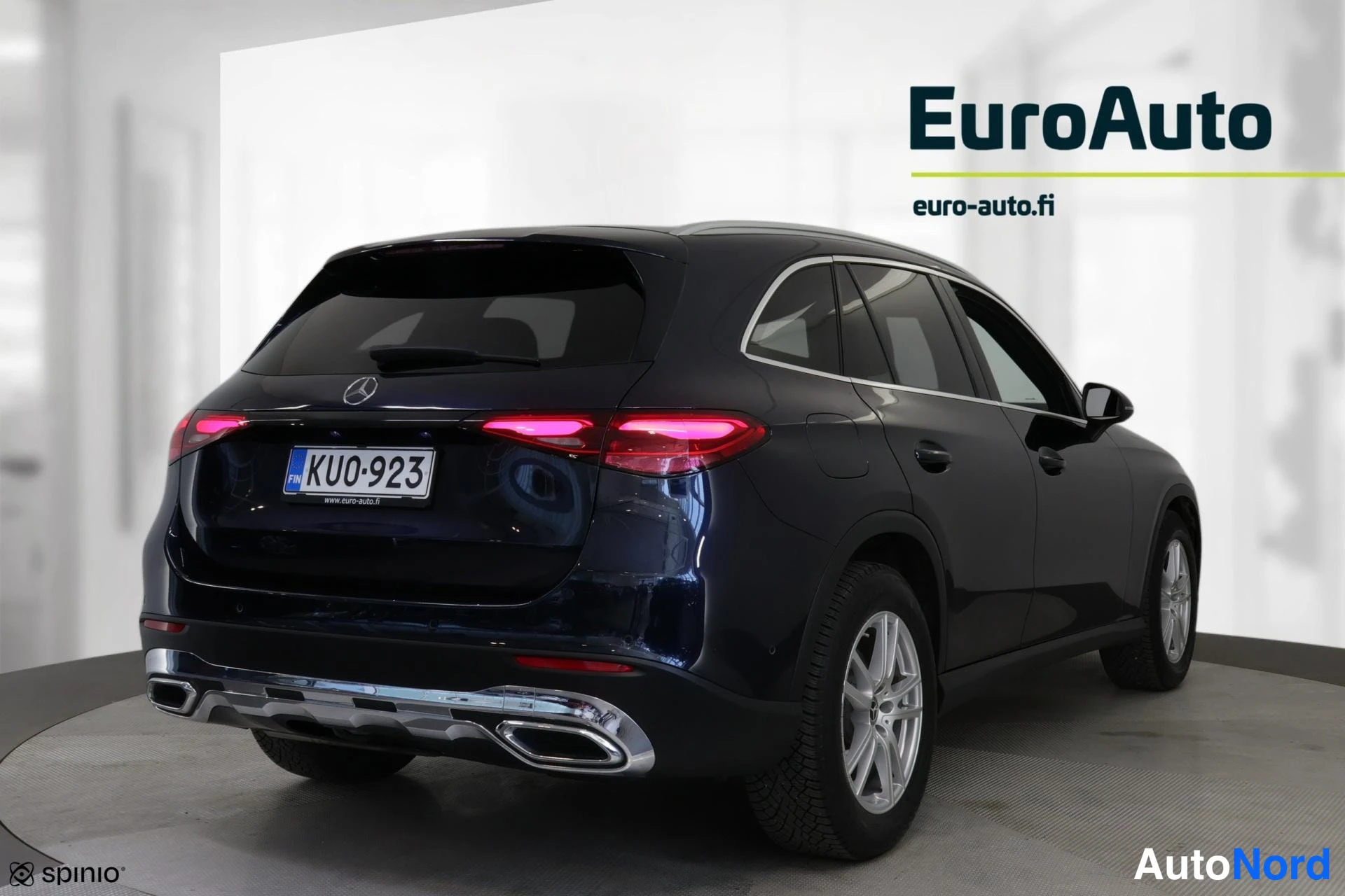 Takaviisto: Pimeänsininen SUV:n taka- ja vasen sivu. Takavalot ovat päällä, kromiputket takapuskurissa.