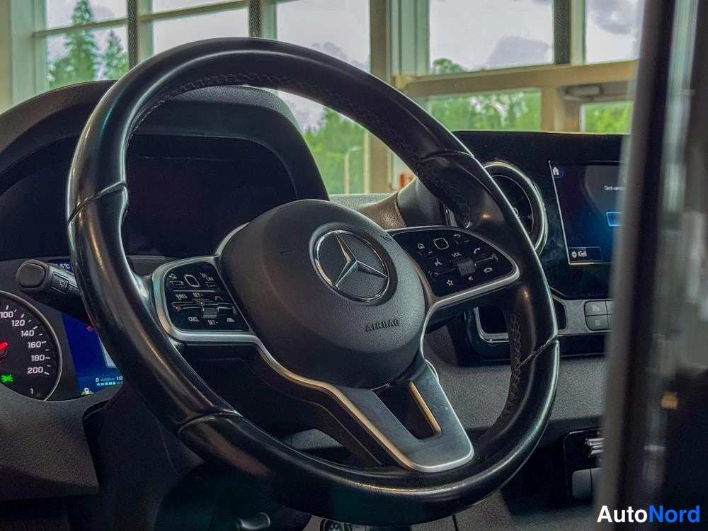 Muu: Ohjauspyörä, jossa Mercedes-tähtimerkki ja AIRBAG-teksti sekä monitoiminapit molemmissa puhkeissa; taustalla näkyy kojelauta ja keskinäyttö.