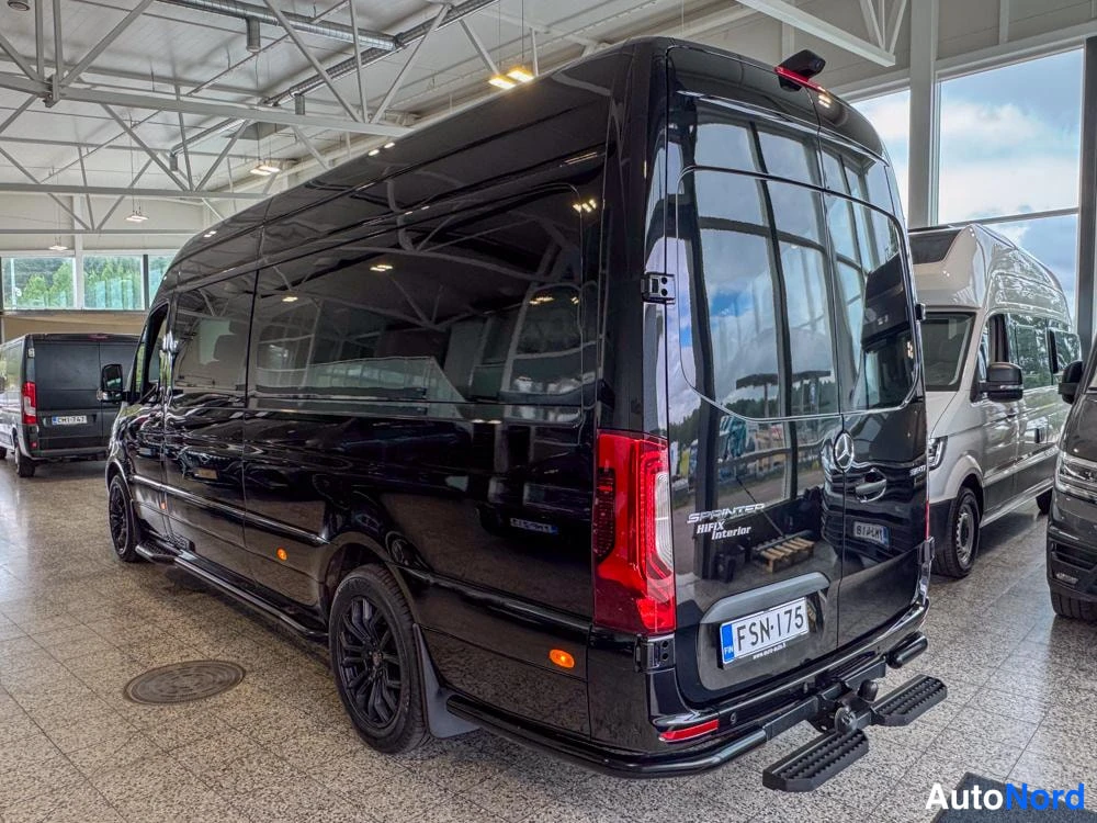 Takaviisto: Musta Mercedes-Benz Sprinter -pakettiauto takakulmasta, perä ja vasen kylki näkyvissä; takana vetokoulu ja rekisteri, takaluukussa Sprinter-teksti.