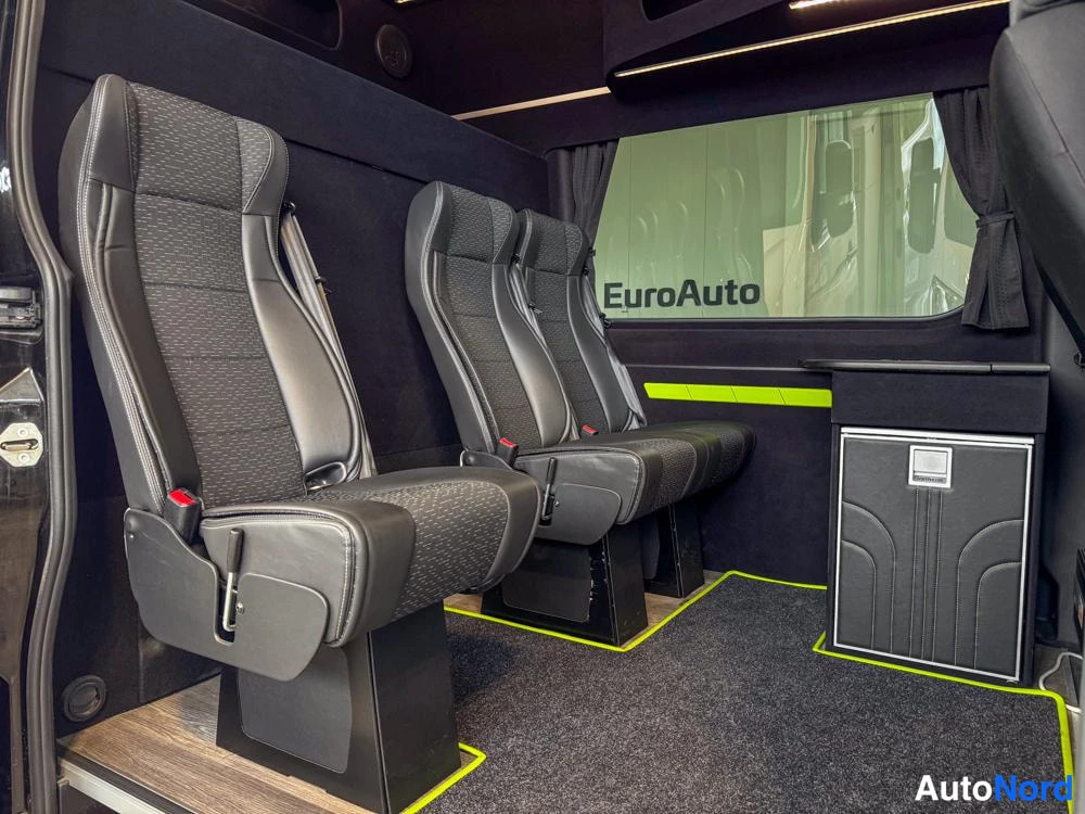Ohjaamo: Rear passenger cabin with four captain seats facing forward and custom lighting trim.