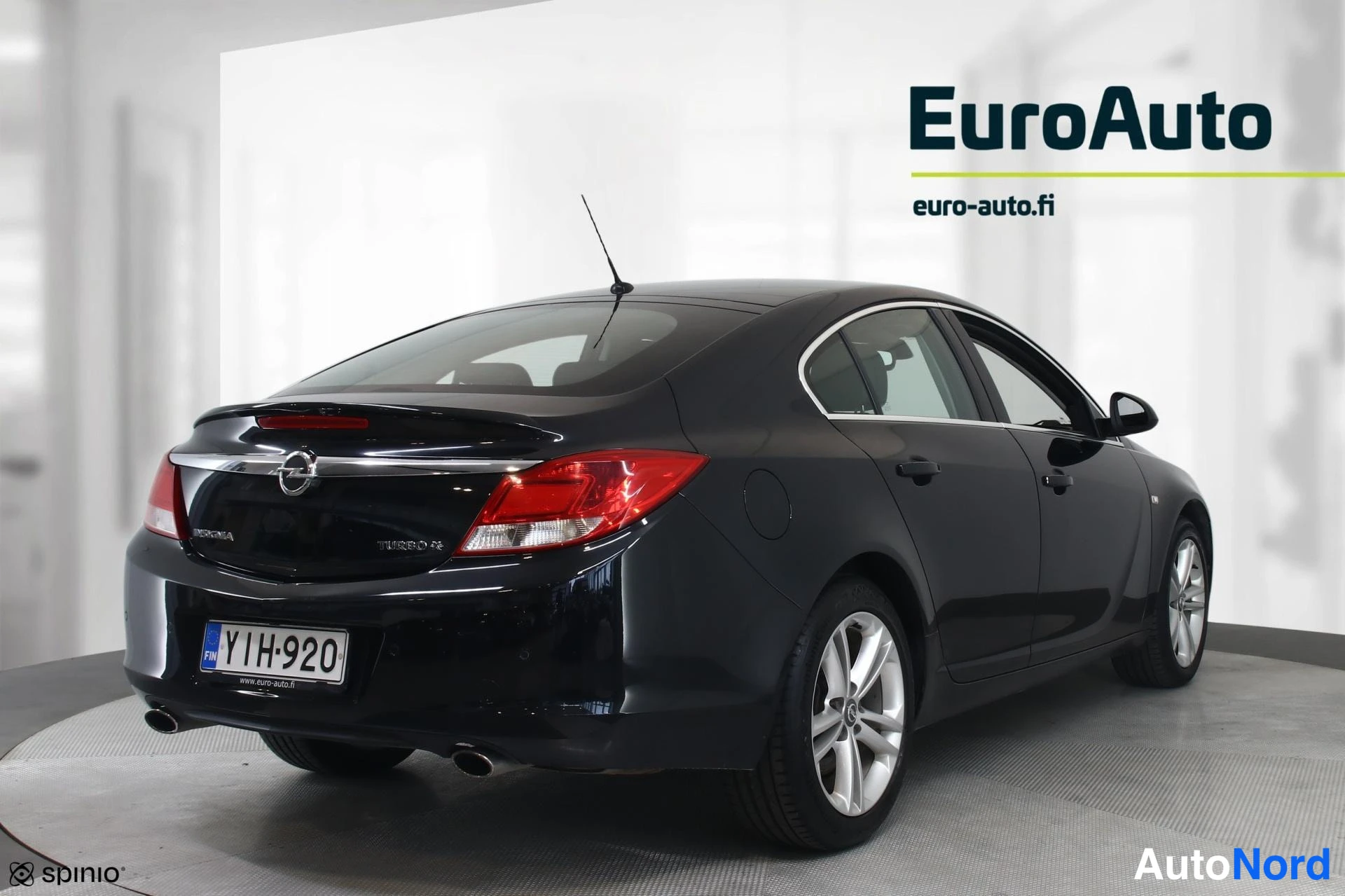 Takaviisto: Musta Opel Insignia -sedan, näkymä auton takaa ja vasemmasta kyljestä