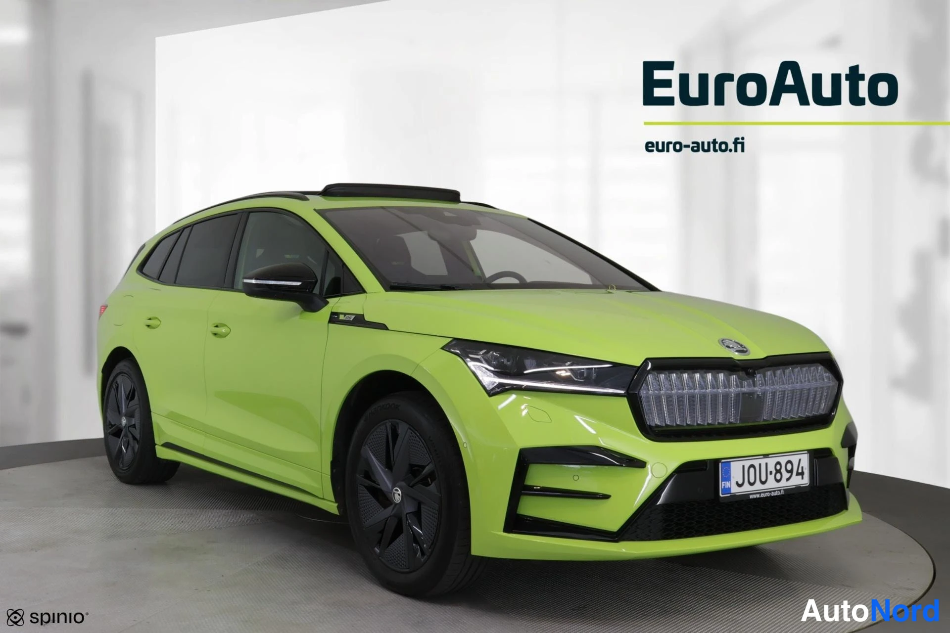 Etuviisto, nokka oikealle: Front three-quarter view of a lime green station wagon. The car is angled to show the front and the right flank.