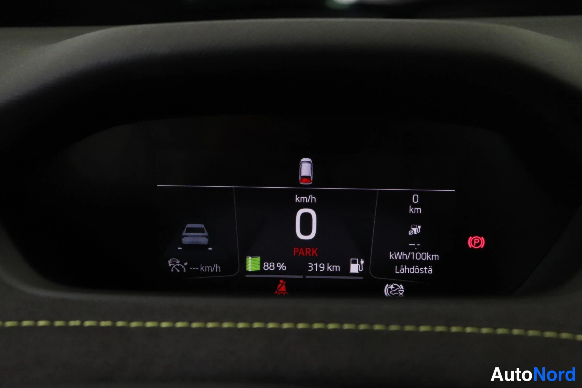 Ohjaamo: Kuvassa on autojen digitaalinen mittaritaulu, jossa on vihreä akun varautumisastetta kuvava merkki (88 %) ja teksti Lähdöstä. Mittaristossa näkyy myös punainen