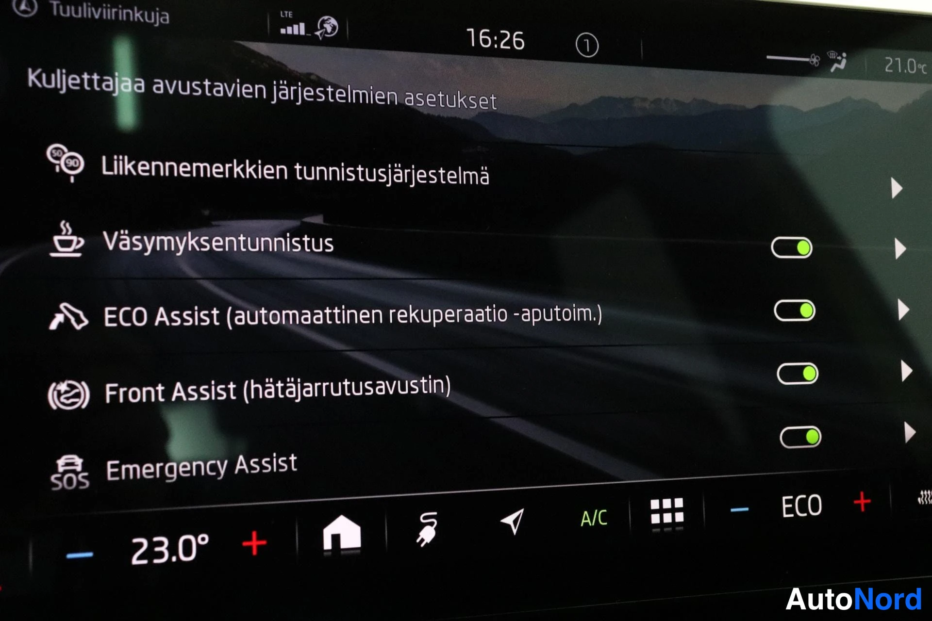 Ohjaamo: Infotainment screen displaying further driver assistance options with toggles. 'Väsymyksen tunnistus' and 'ECO Assist (automaattinen rekuperaatio -aputoim.)' an