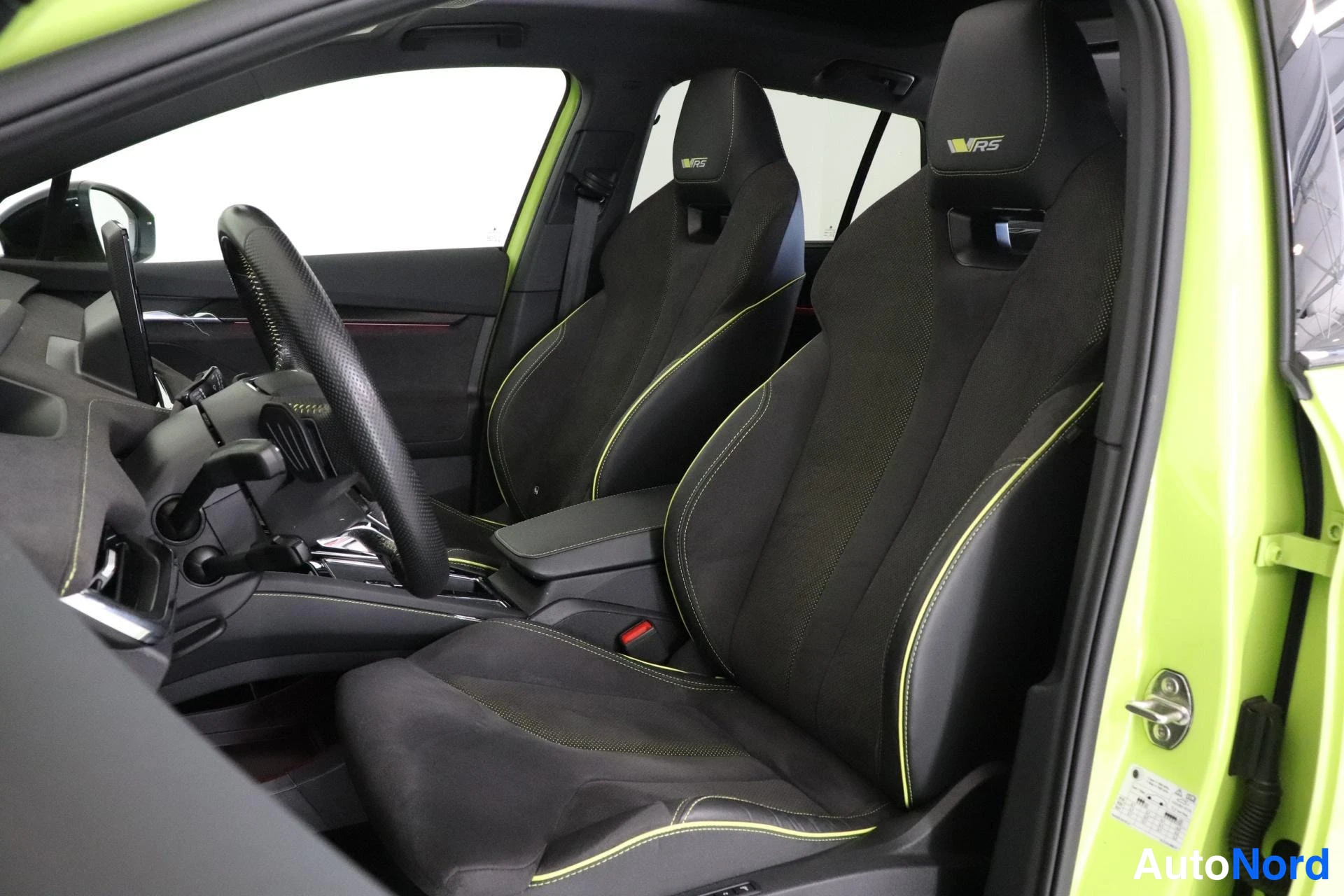Etuistuimet: Interior front seats shot showing two black sport seats with 'RS' embroidery and yellow contrast stitching on the headrests.